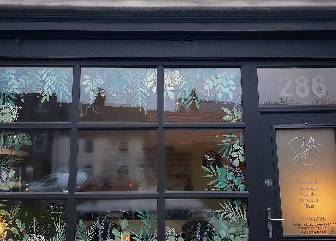 SB Wellbeing entrance with botanical designs at Chesterfield, England, GB showcasing services like Ayurveda and facials.