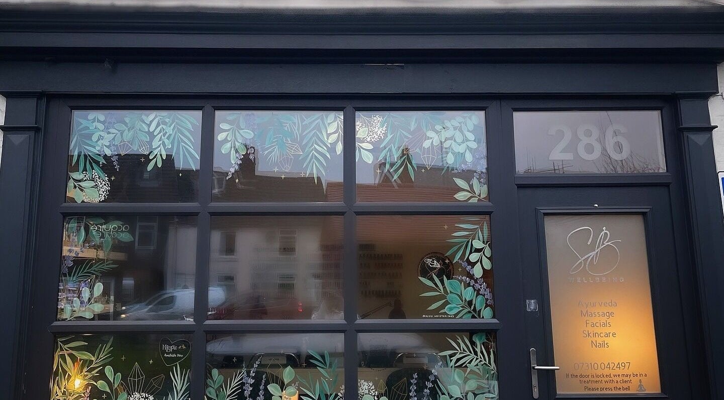 SB Wellbeing entrance with botanical designs at Chesterfield, England, GB showcasing services like Ayurveda and facials.