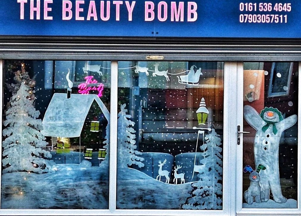 Festive window art at DMD Aesthetics in Eccles, England, GB showcasing winter scenes.