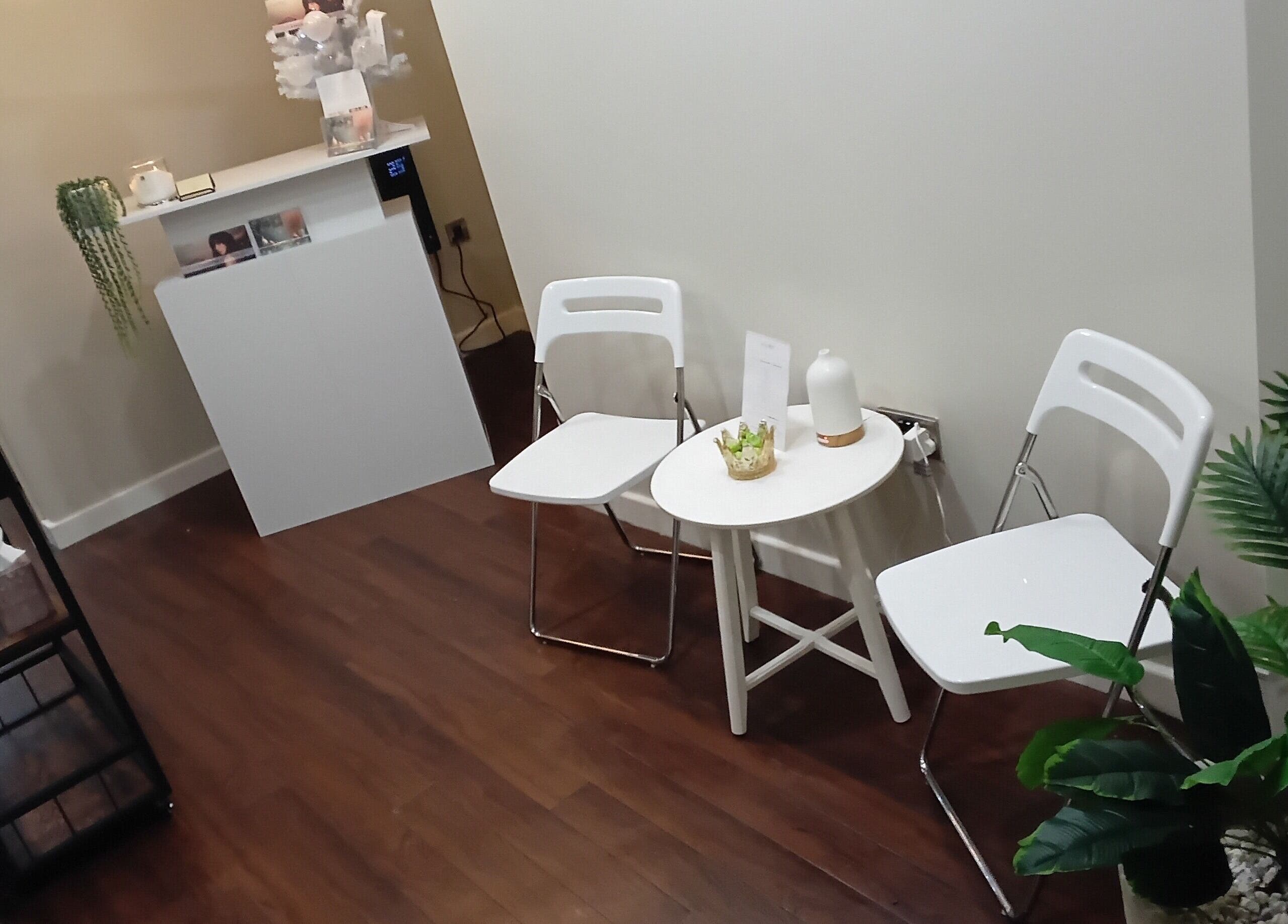 Cozy waiting area at RK Skin & Sole Ltd, Leeds, England, GB with chairs, table, and plants.