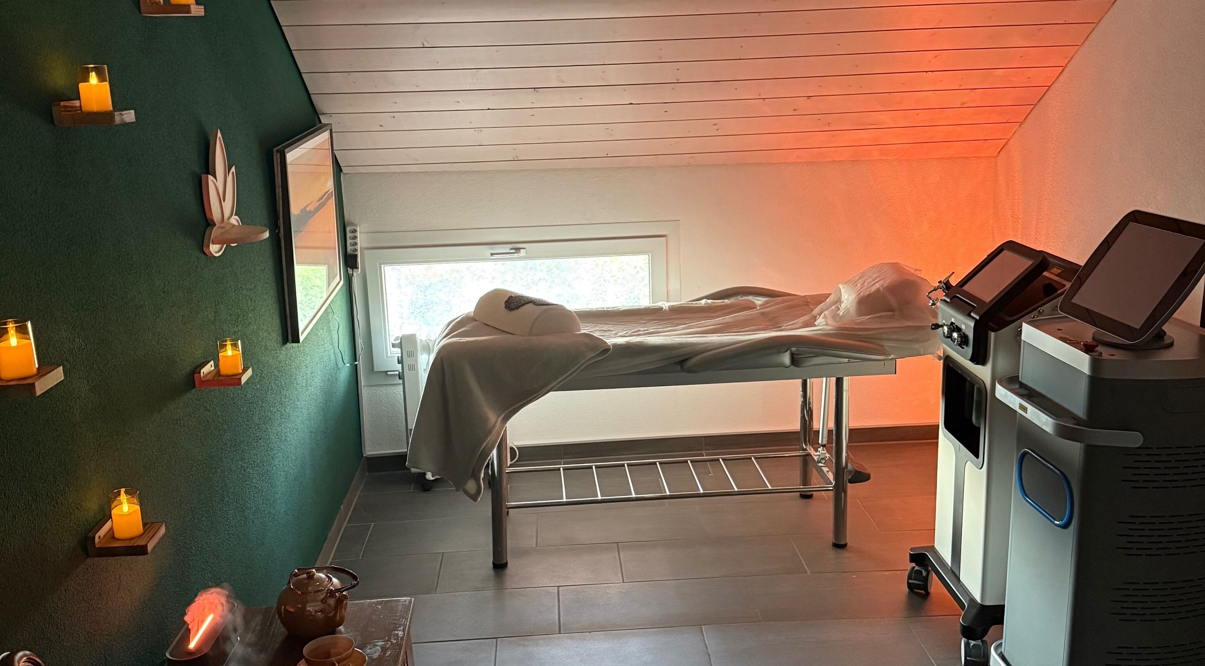 Salle de soin confortable chez Malee, Eclagnens, Vaud, CH, avec table de massage et lumière apaisante.