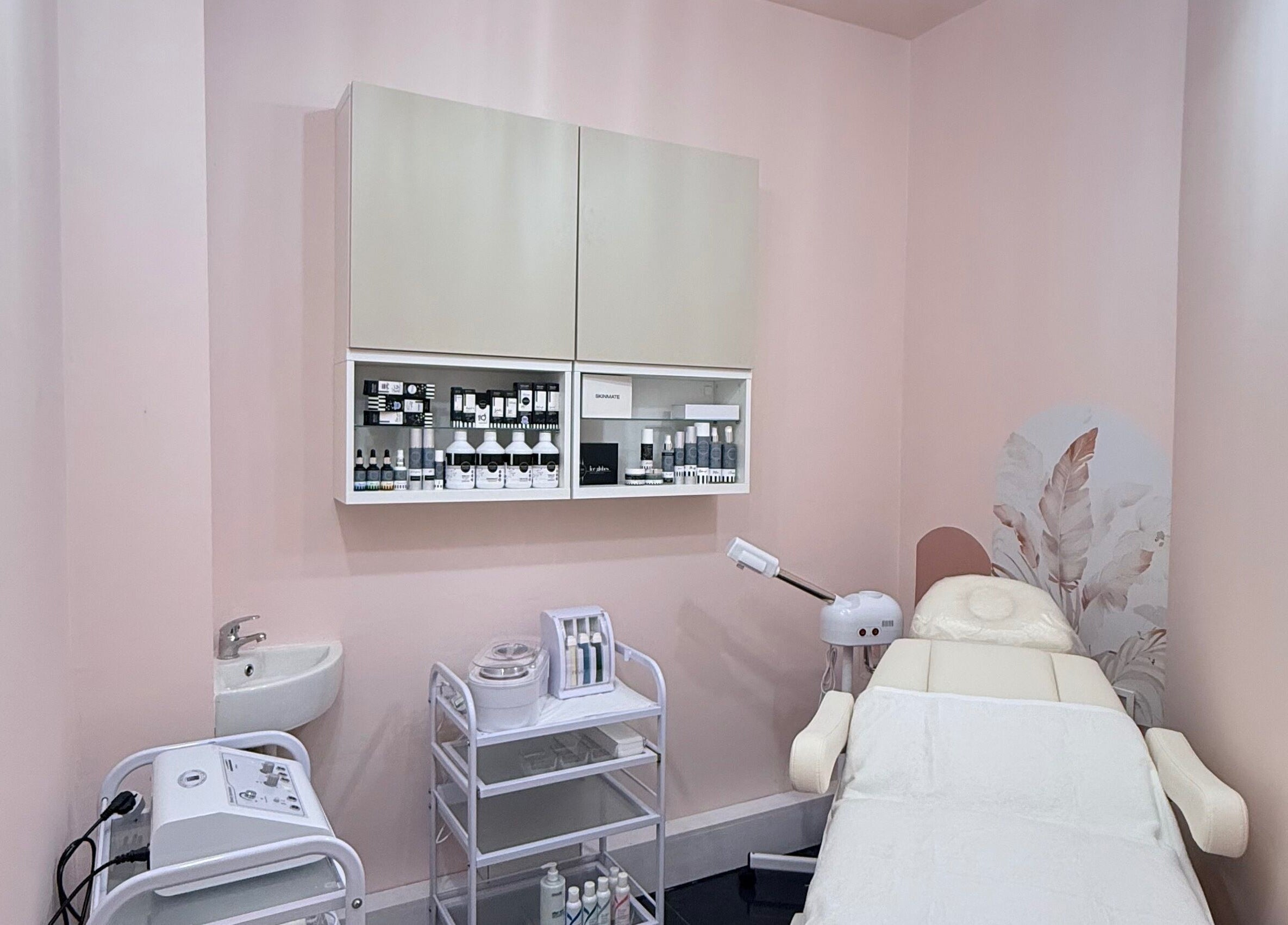 Treatment room at Elegance Beauty and Aesthetics, London, England, GB with pink decor and skincare products.