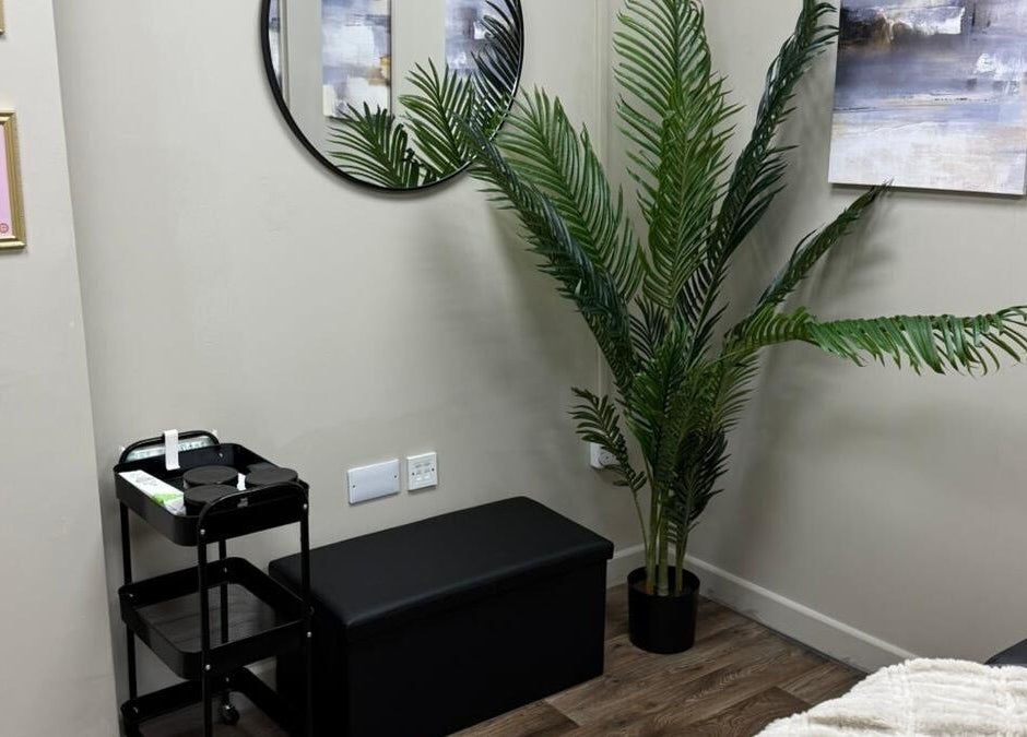 Peaceful corner at Pearls of Beauty, Hastings, England, GB with plant, mirror, and certificates.