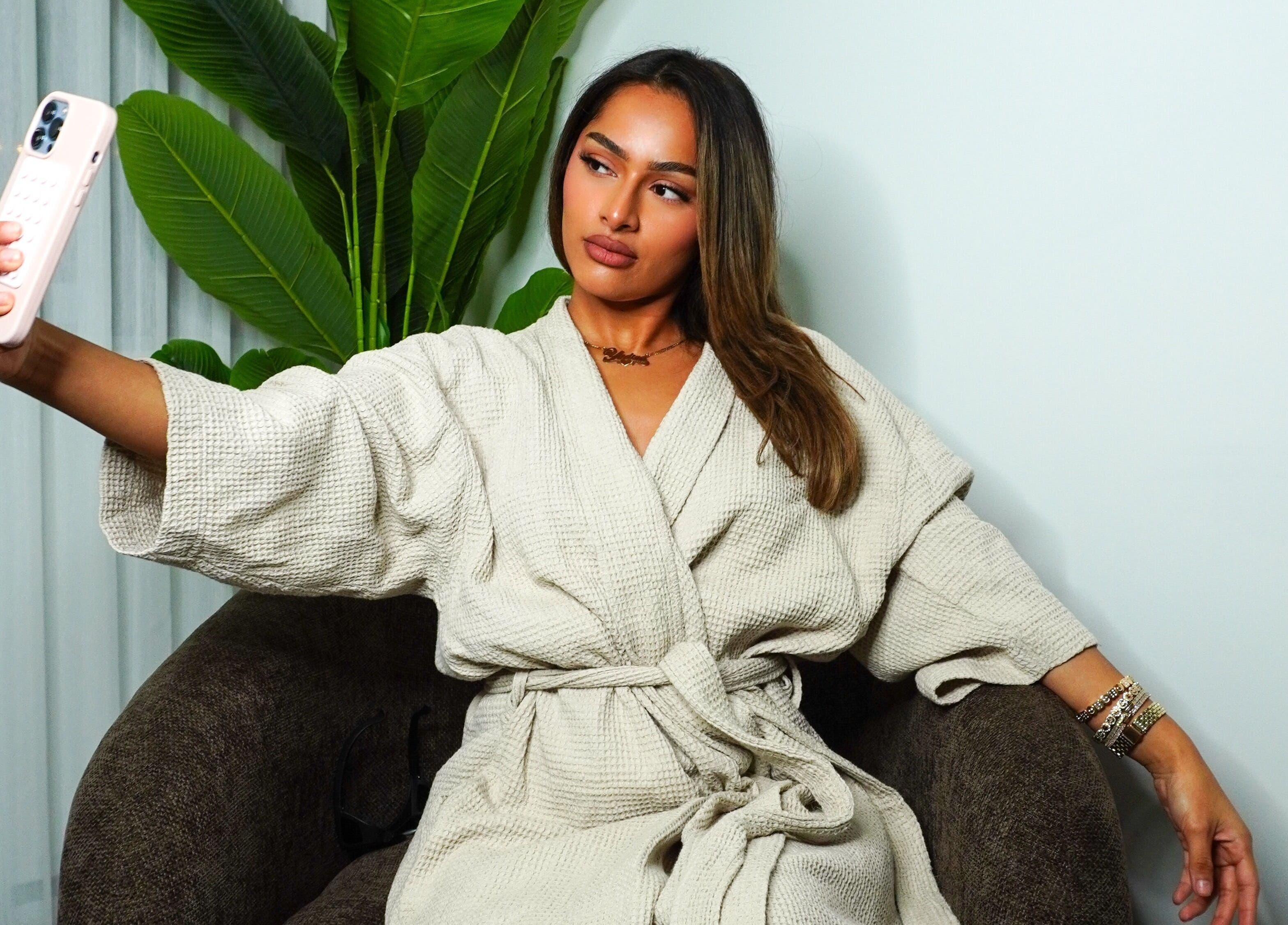 Woman in robe takes a selfie at Vivacci Skin, Montréal, Québec, CA, showcasing spa relaxation.