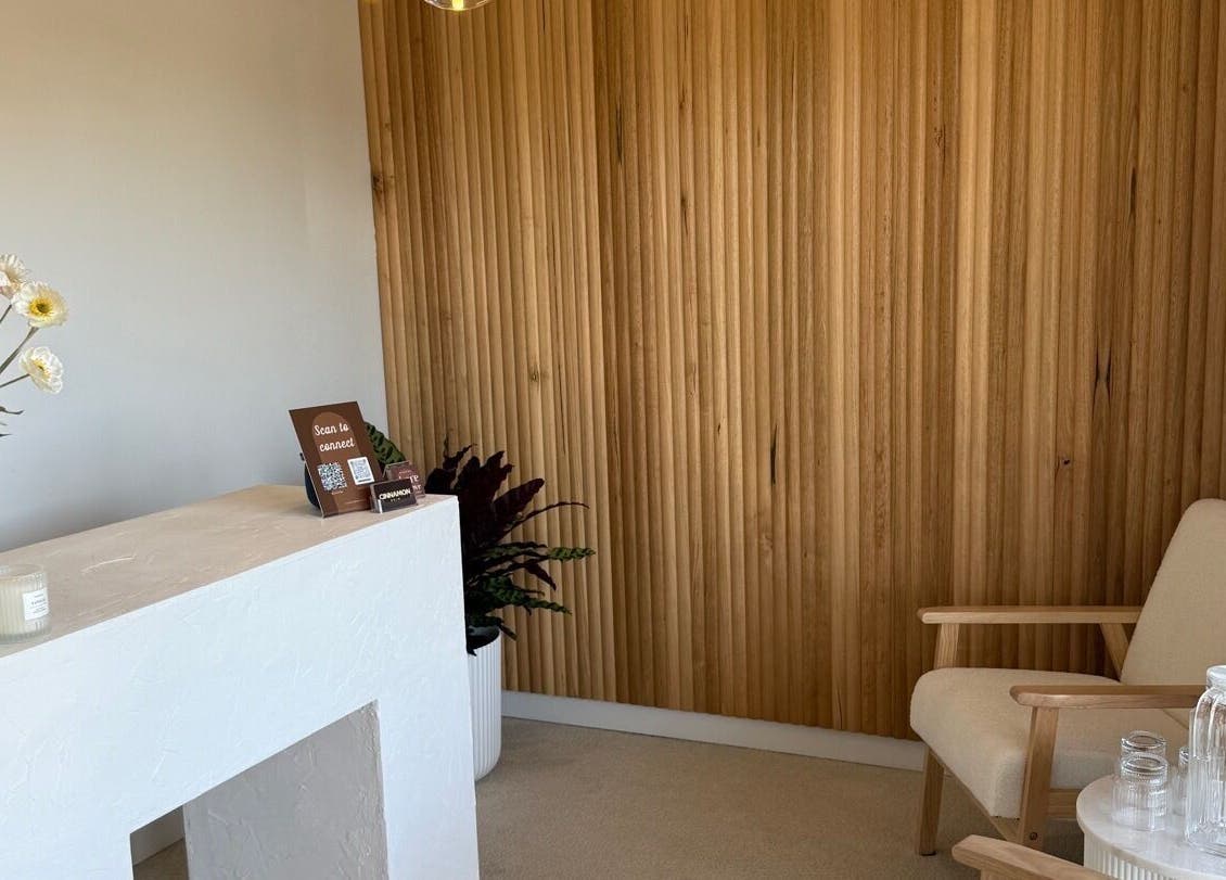 Cozy reception area at Tyde Beauty Studio in Southport, Queensland, AU with wooden decor and floral accents.