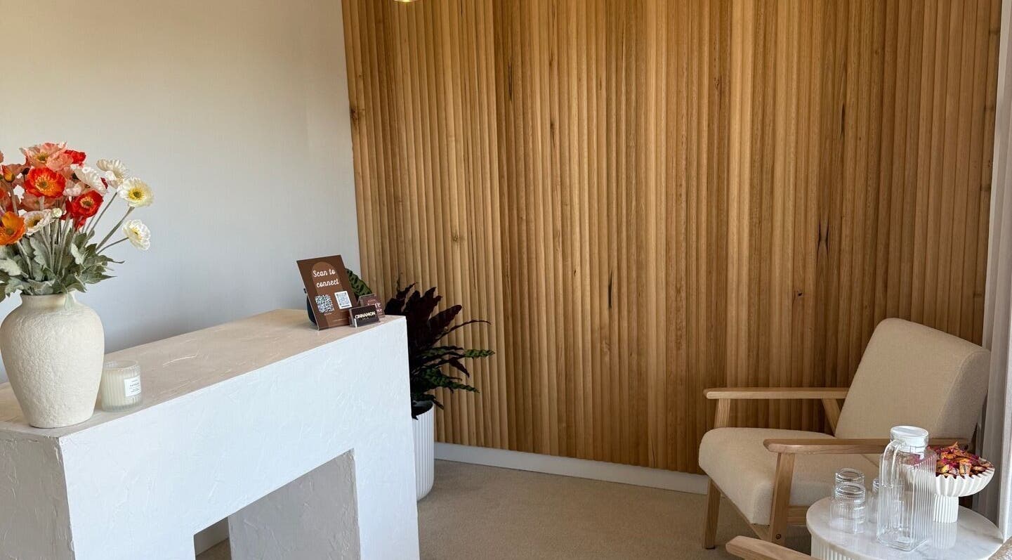 Cozy reception area at Tyde Beauty Studio in Southport, Queensland, AU with wooden decor and floral accents.