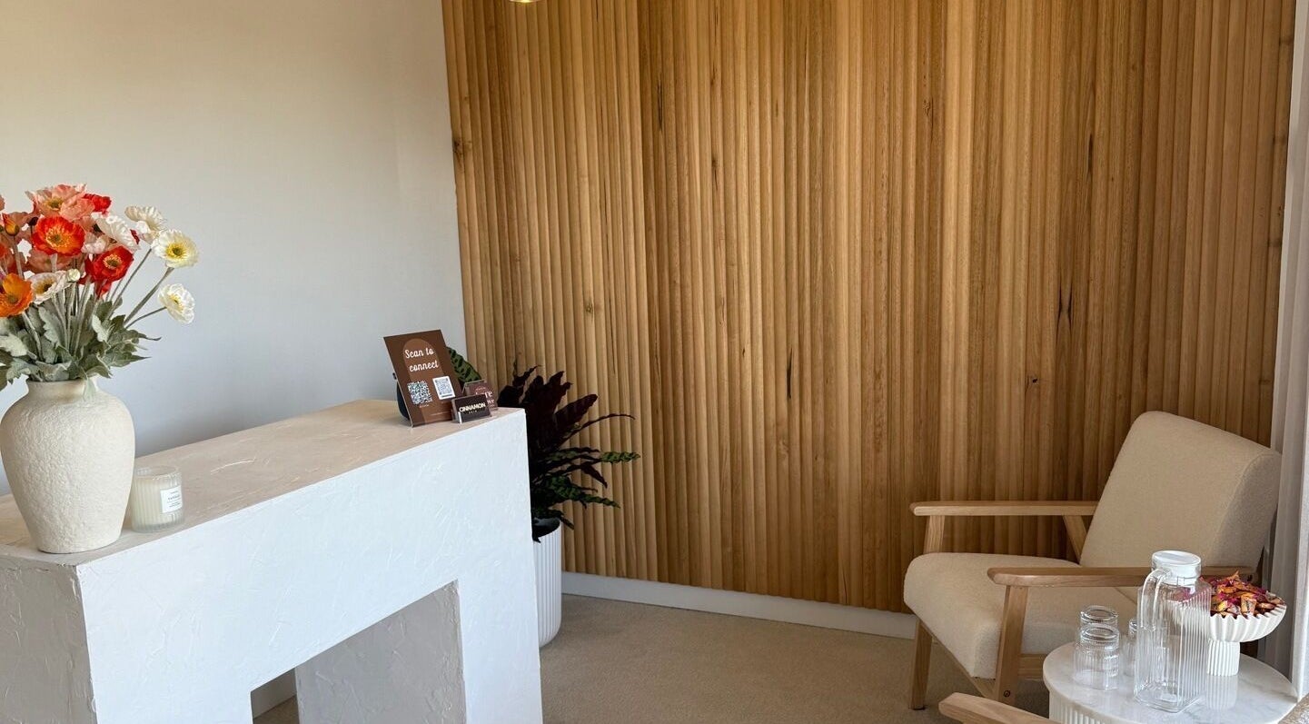 Cozy reception area at Tyde Beauty Studio in Southport, Queensland, AU with wooden decor and floral accents.