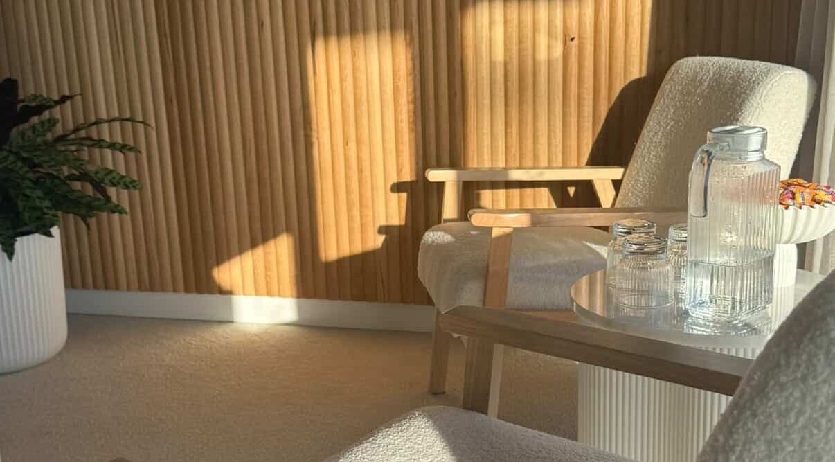 Cozy lounge area at Tyde Beauty Studio, Southport, Queensland, AU with wooden accents and sunlight.