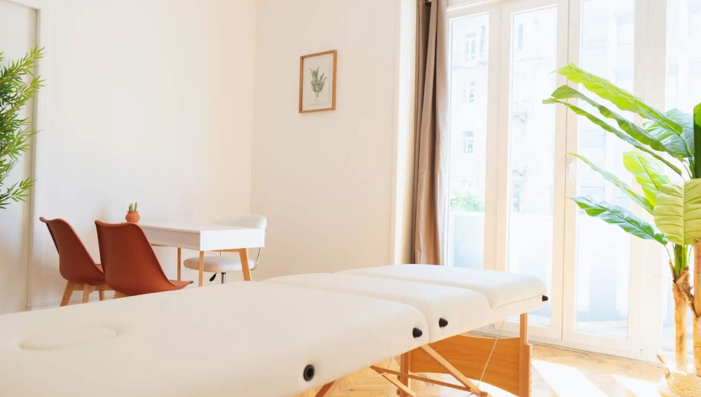 Sala de tratamento serena em Wellzen by Diana, Lisboa, Lisboa, PT com cama de massagem e plantas.