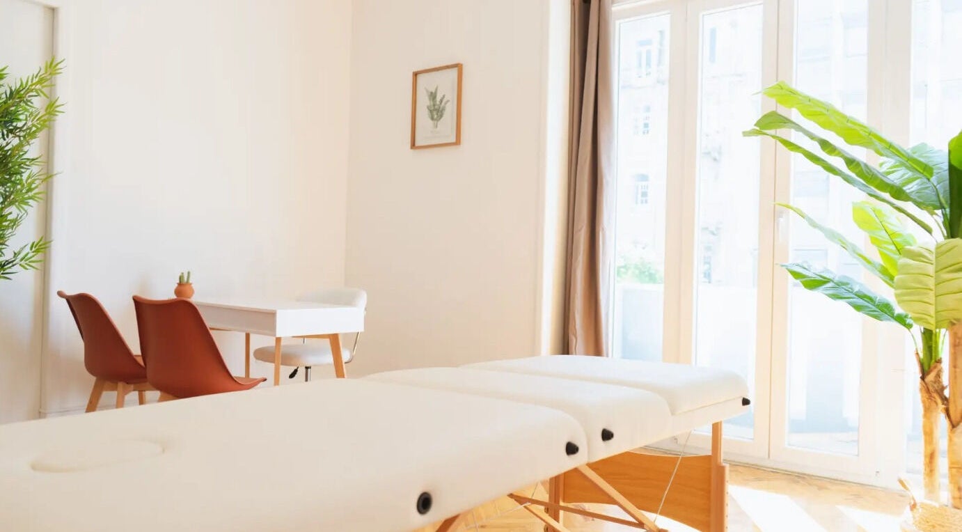 Sala de tratamento serena em Wellzen by Diana, Lisboa, Lisboa, PT com cama de massagem e plantas.