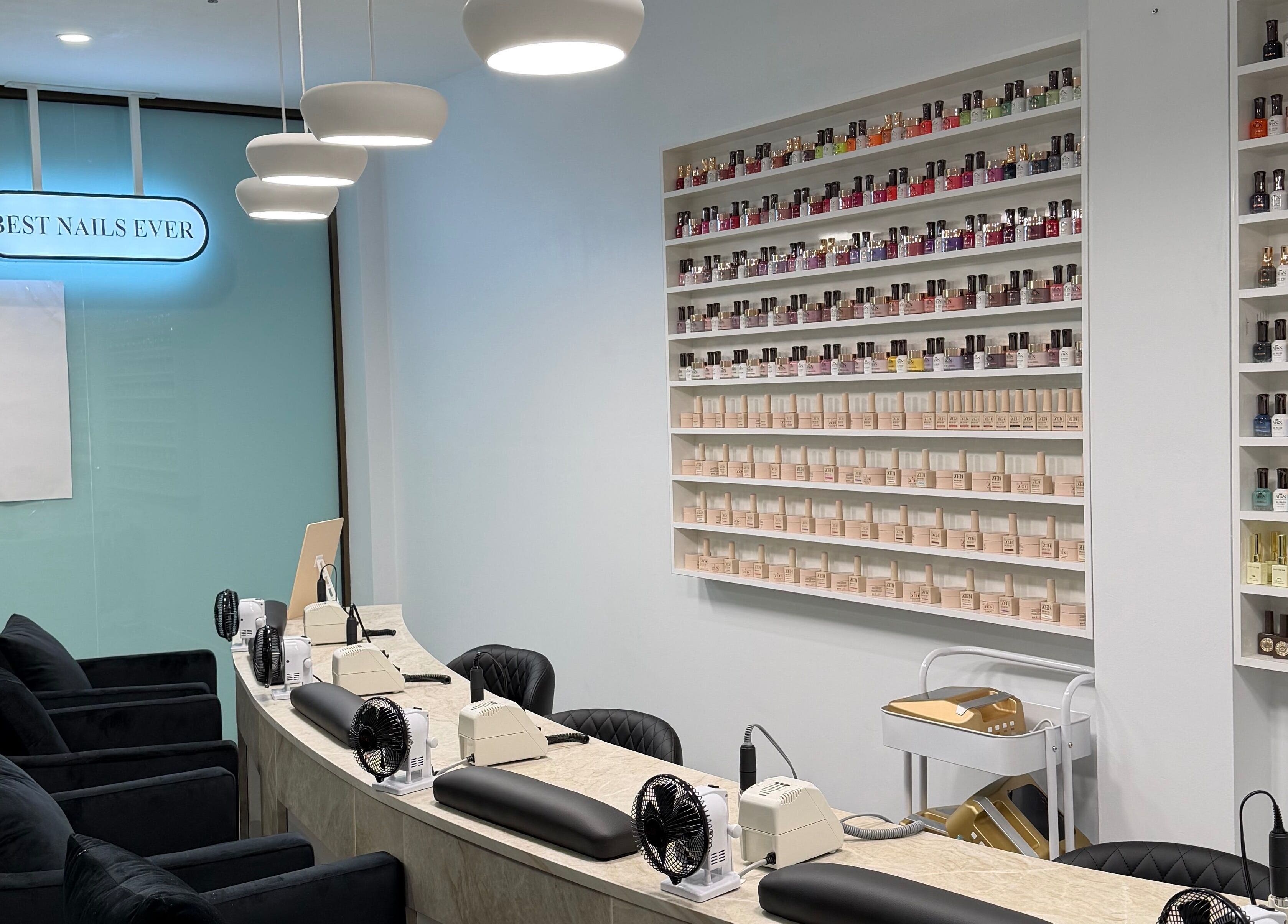 Elegant nail salon interior at Best Nails Ever, Melbourne, Victoria, AU with colorful polishes on display.