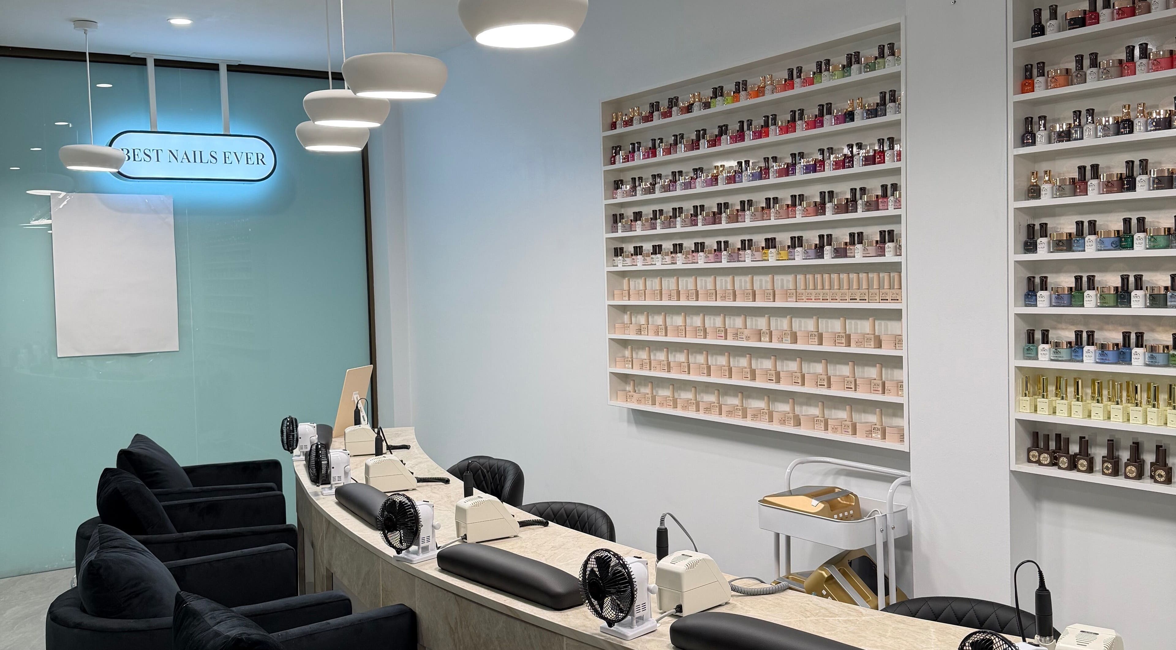 Elegant nail salon interior at Best Nails Ever, Melbourne, Victoria, AU with colorful polishes on display.