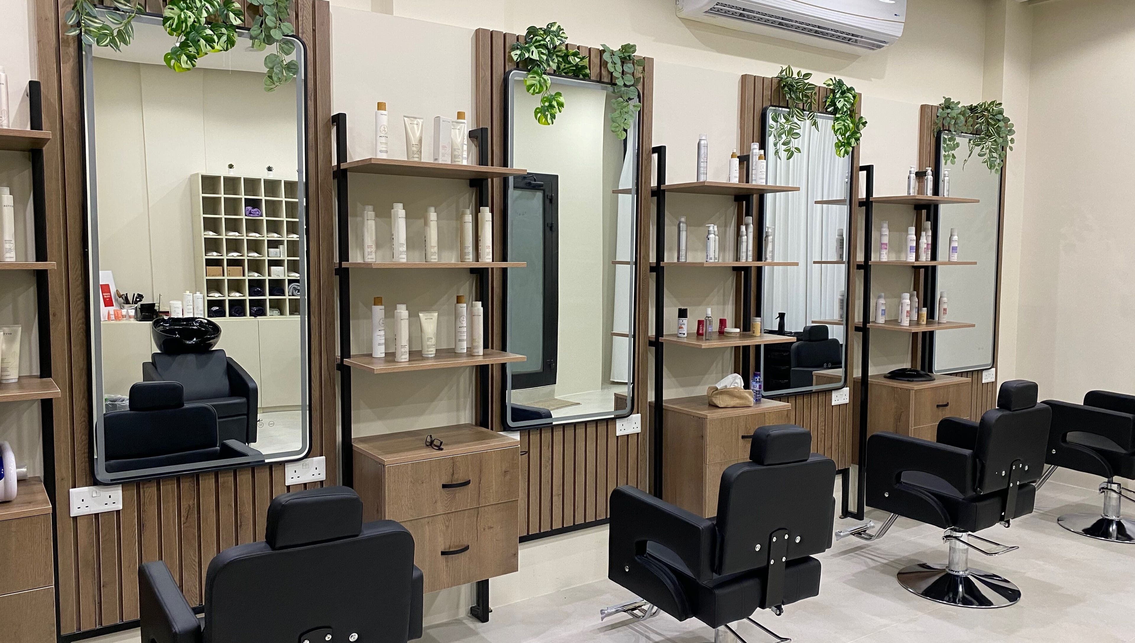 Modern salon setup at Hair & More by Hanan, Al Hidd, Muḥāfaẓat Al-muḥarraq, BH with stylish chairs and product shelves.
