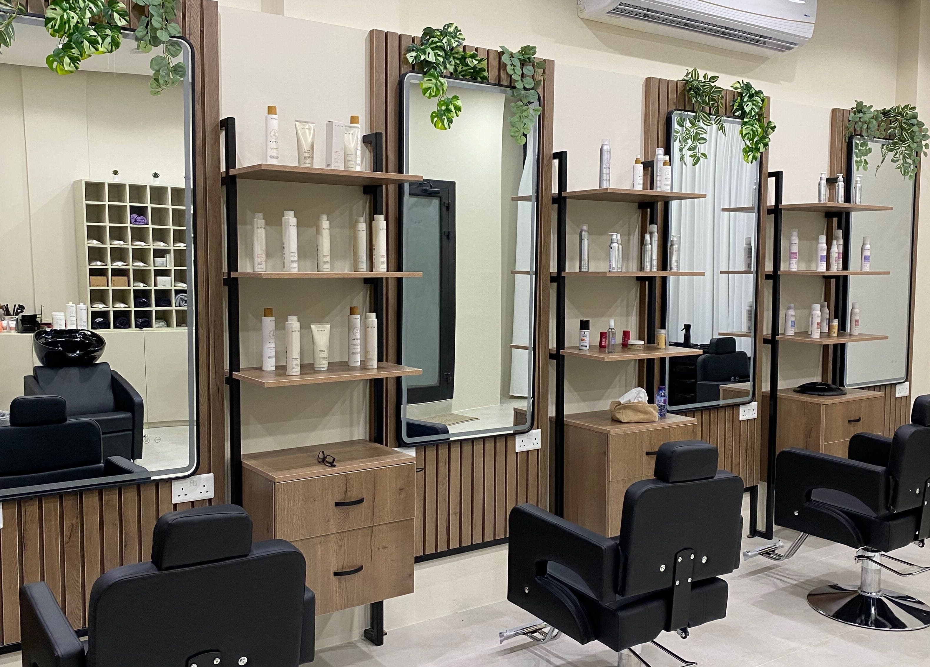 Modern salon setup at Hair & More by Hanan, Al Hidd, Muḥāfaẓat Al-muḥarraq, BH with stylish chairs and product shelves.
