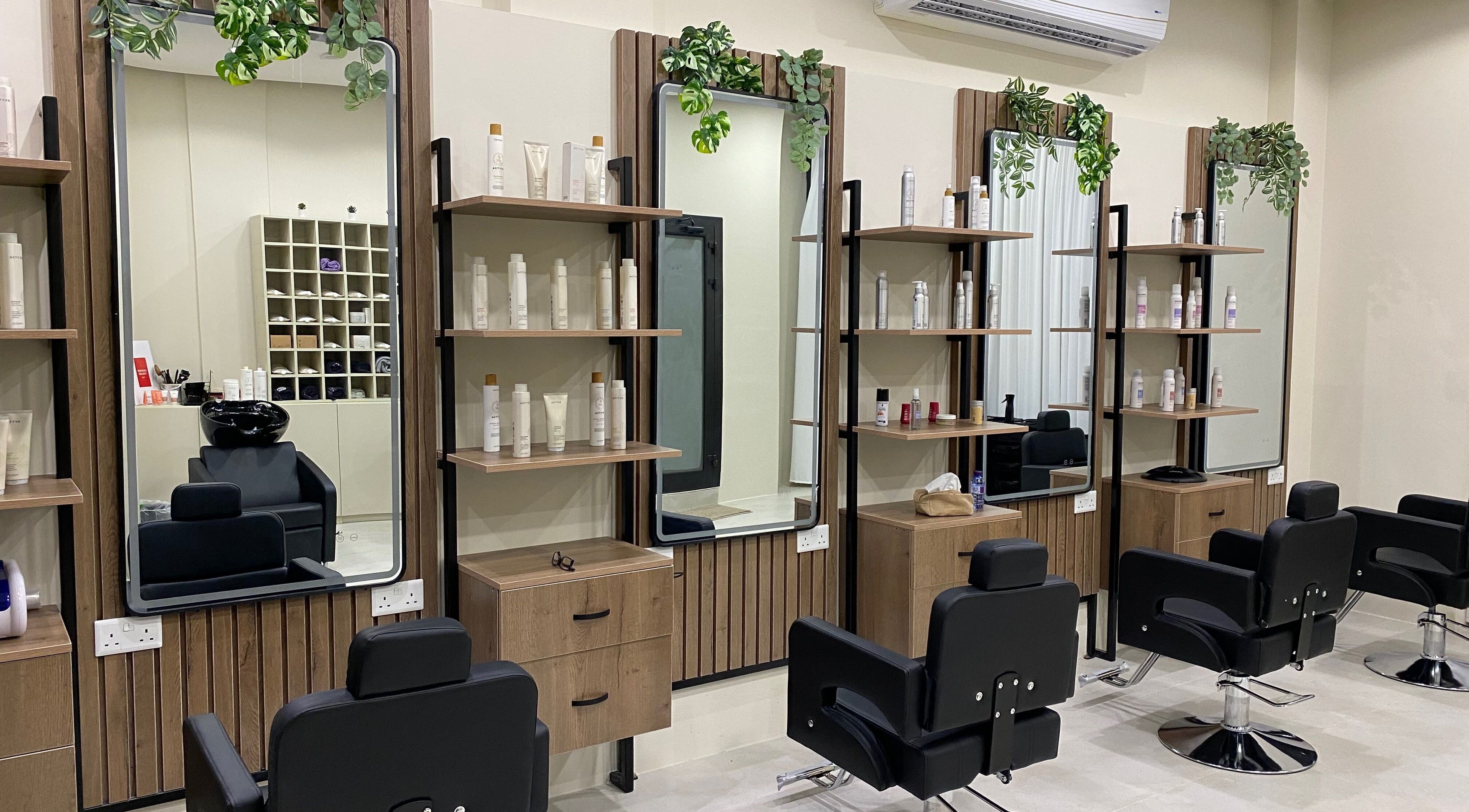 Modern salon setup at Hair & More by Hanan, Al Hidd, Muḥāfaẓat Al-muḥarraq, BH with stylish chairs and product shelves.