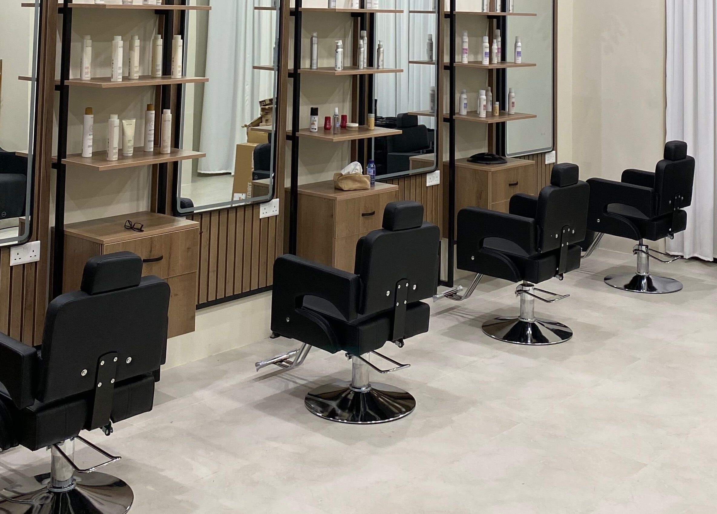 Modern salon setup at Hair & More by Hanan, Al Hidd, Muḥāfaẓat Al-muḥarraq, BH with stylish black chairs.