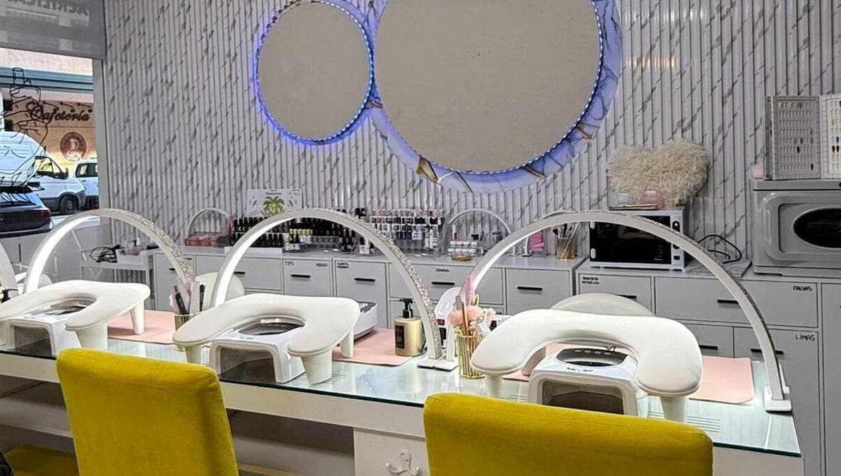 Interior moderno de Estética la favorita, Alcalá De Henares, con estaciones de manicura blancas y espejos circulares.