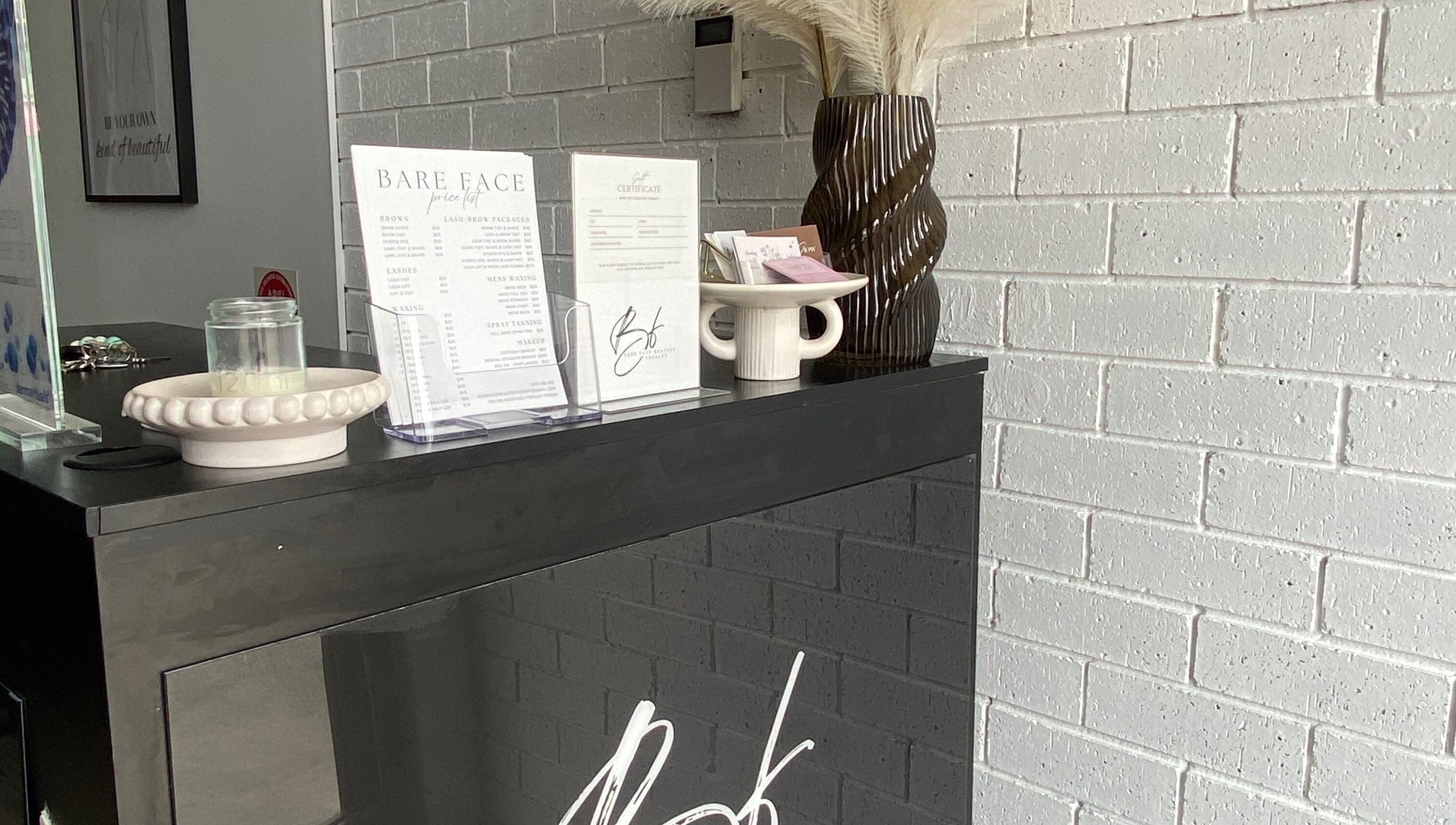 Reception desk at Makeup By Laura Lebret, Toukley, New South Wales, AU with decor and service menu.
