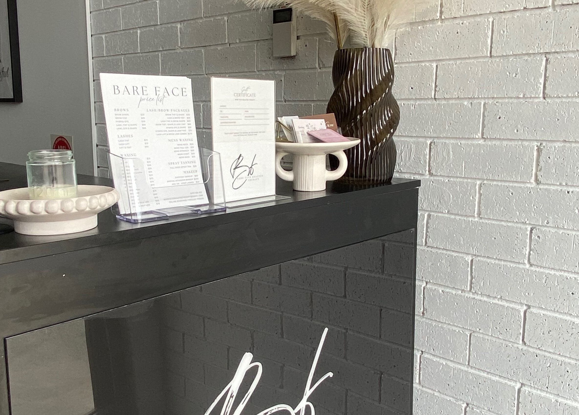 Reception desk at Makeup By Laura Lebret, Toukley, New South Wales, AU with decor and service menu.