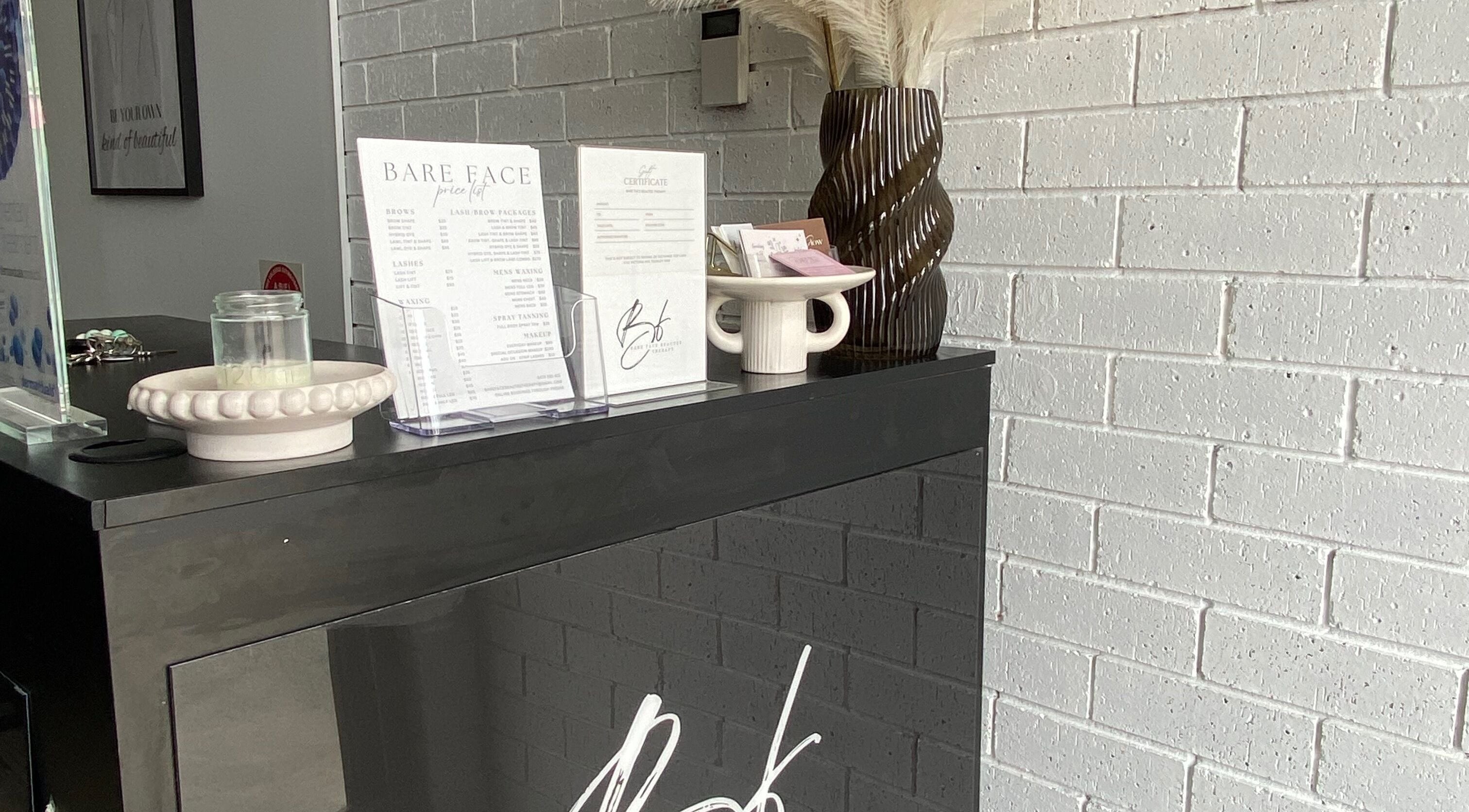 Reception desk at Makeup By Laura Lebret, Toukley, New South Wales, AU with decor and service menu.