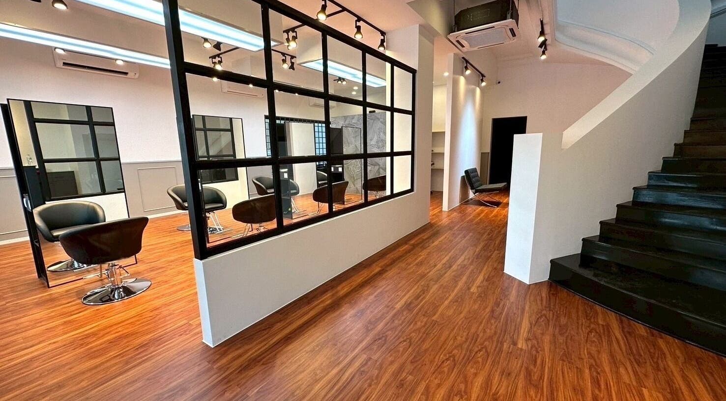 Modern salon interior at melco HairDesign, Phnom Penh, Phnom Penh, KH, featuring sleek black chairs and mirrors.