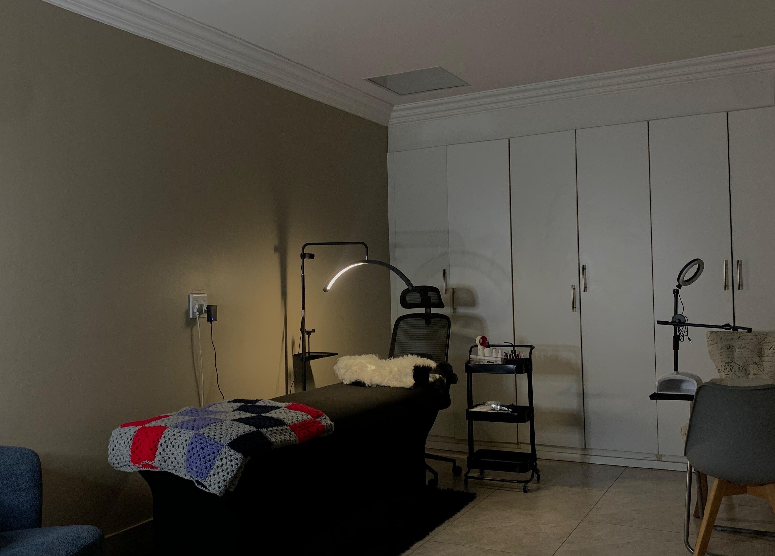 Relaxing treatment room at Vinyl Vici, Pretoria, Gauteng, ZA, featuring a comfy chair and a sleek lamp.