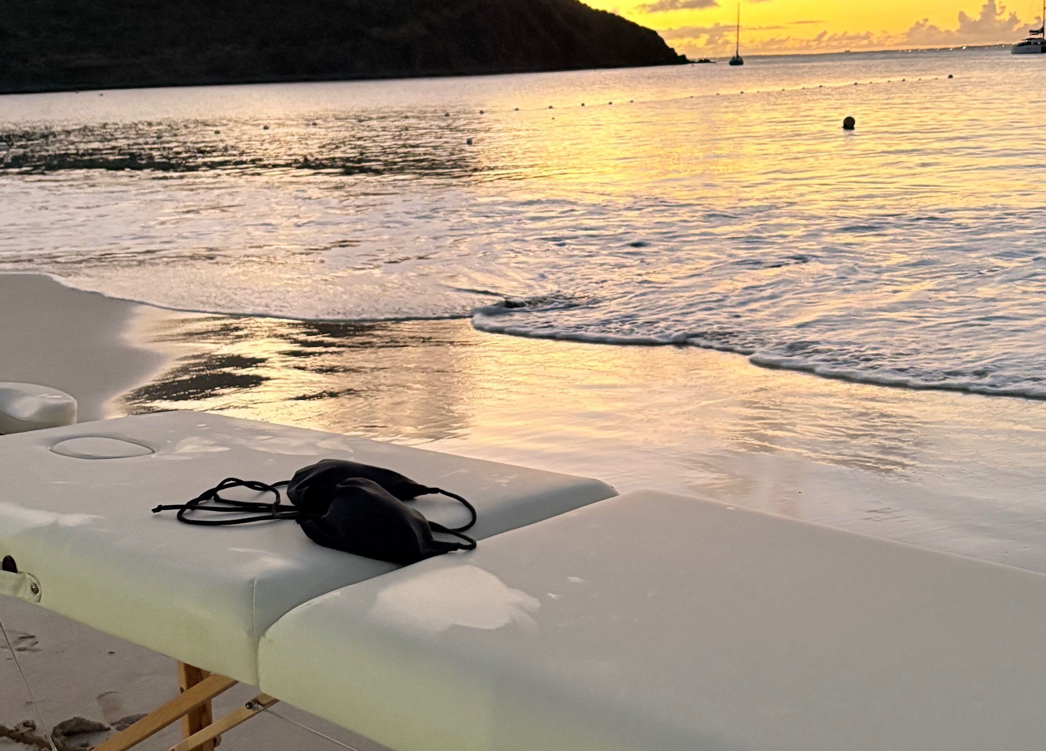 Relaxing beachfront massage setup at Theglamfactorysx/Thehealing haven in Marigot, MF during sunset.