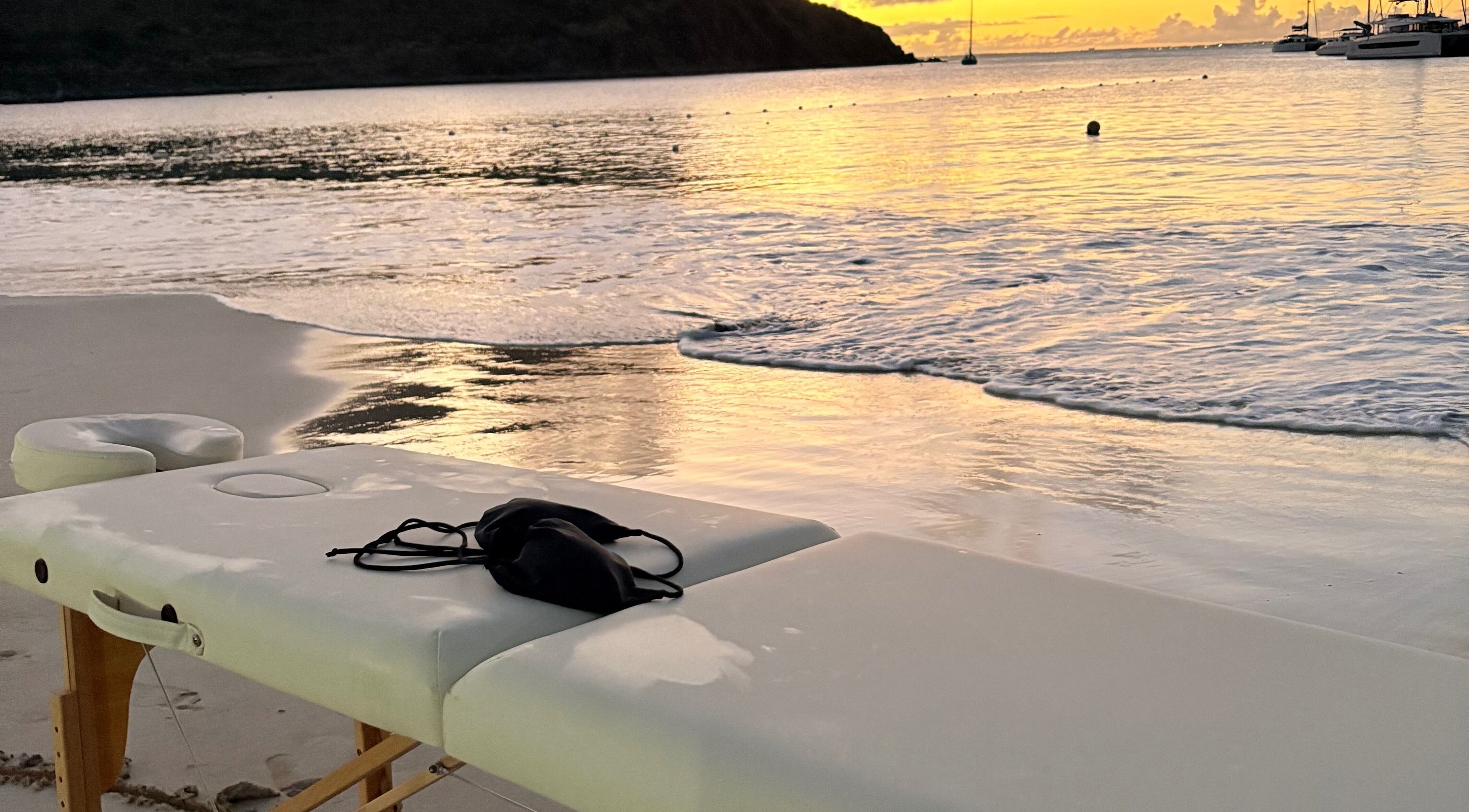 Relaxing beachfront massage setup at Theglamfactorysx/Thehealing haven in Marigot, MF during sunset.