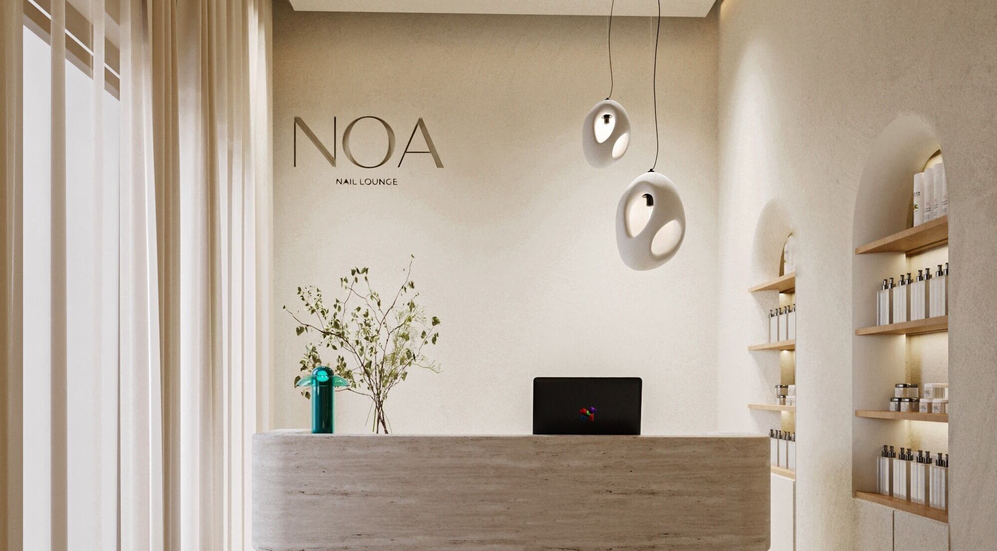 Elegant reception area at NOA Nails, Abu Dhabi, AE showcasing modern design with lighting and shelves.