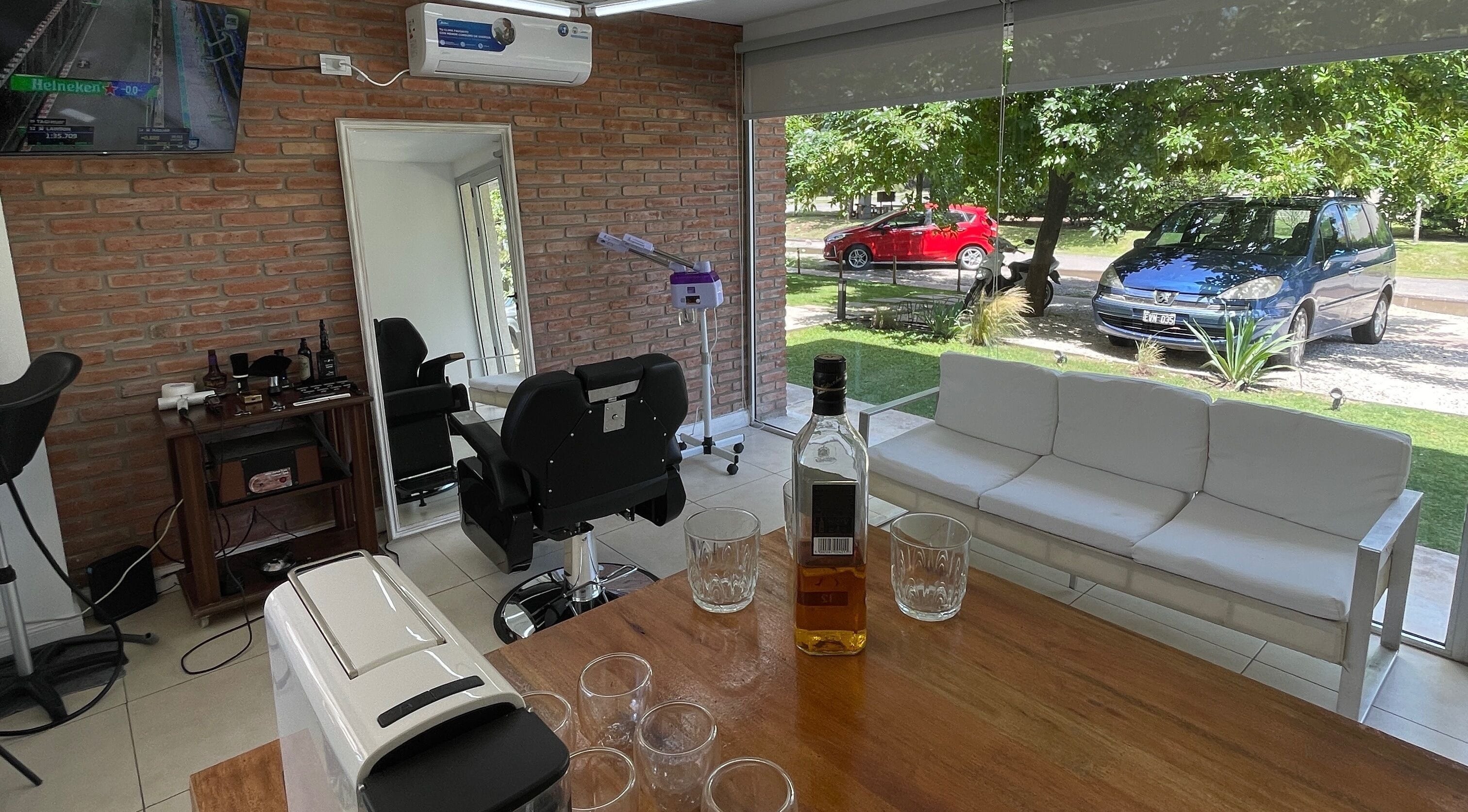 Interior moderno de Golden Blade Barbershop en Rosario, Santa Fe, AR con sillón y espejo.