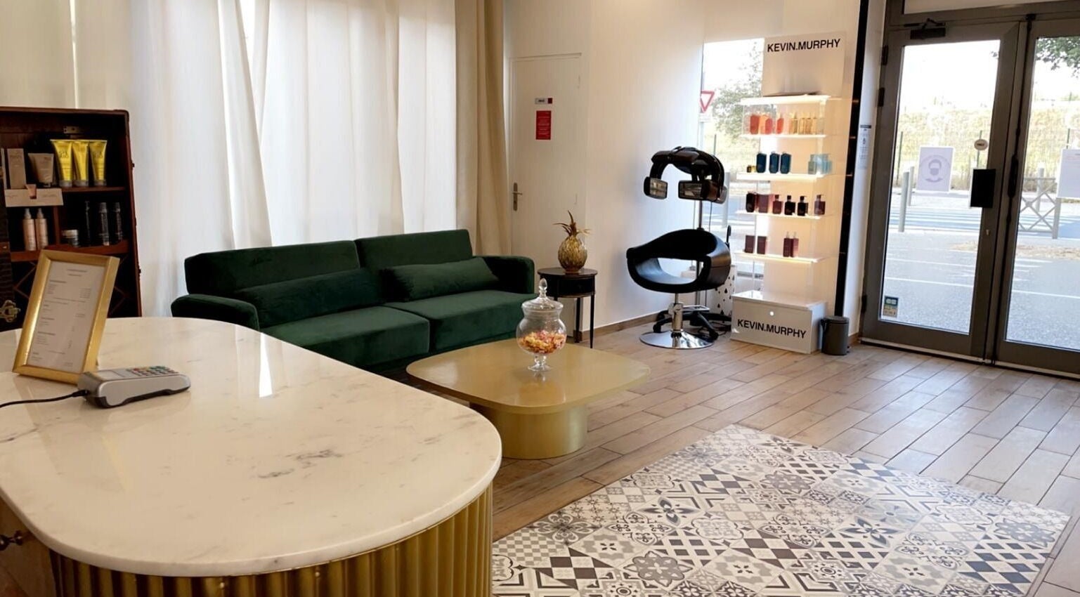 Intérieur élégant de La Parisienne Beauty, Nanterre, Île-de-france, FR avec canapé vert et étagères de produits.