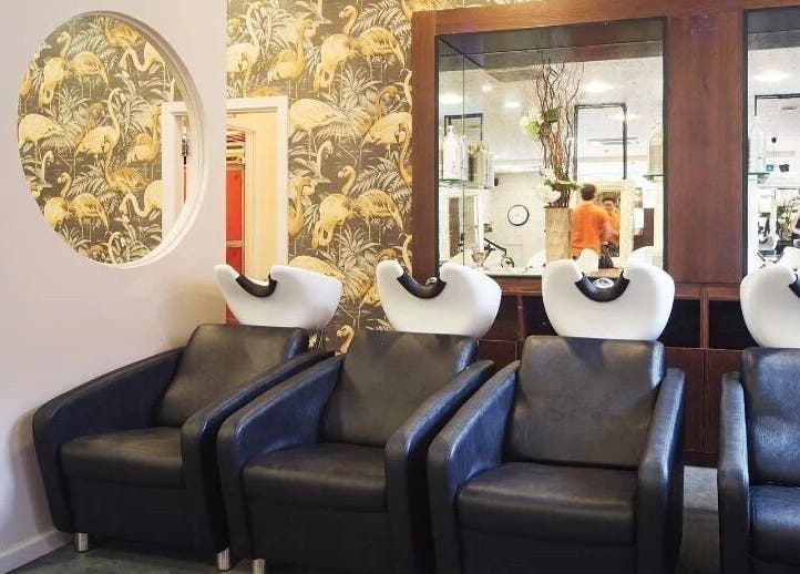 Elegant wash area at Renegade hair studio, Leeds, England, GB with stylish flamingo wallpaper.