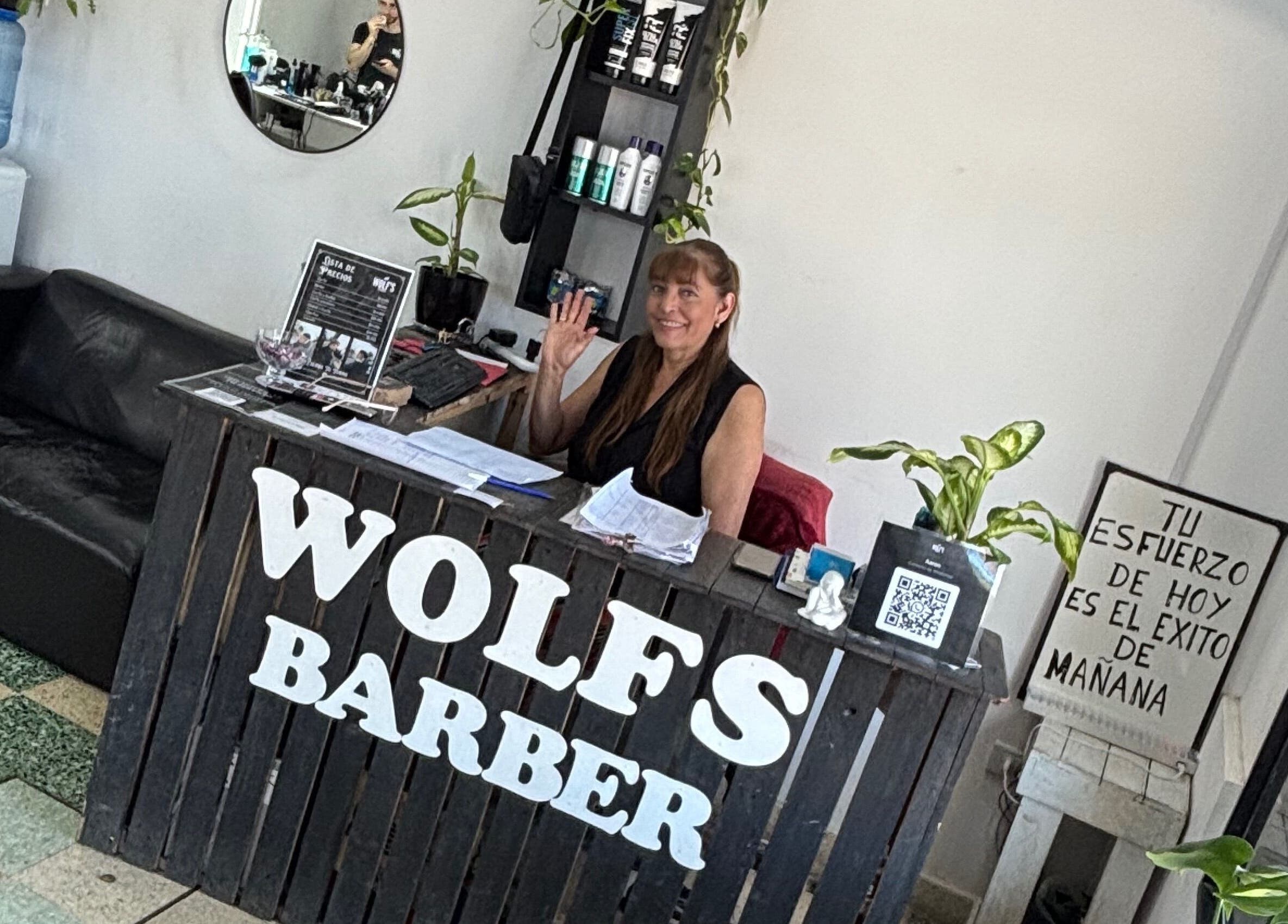 Reception area of Wolf’s Barberia in Ensenada, Provincia De Buenos Aires, featuring a friendly staff member.