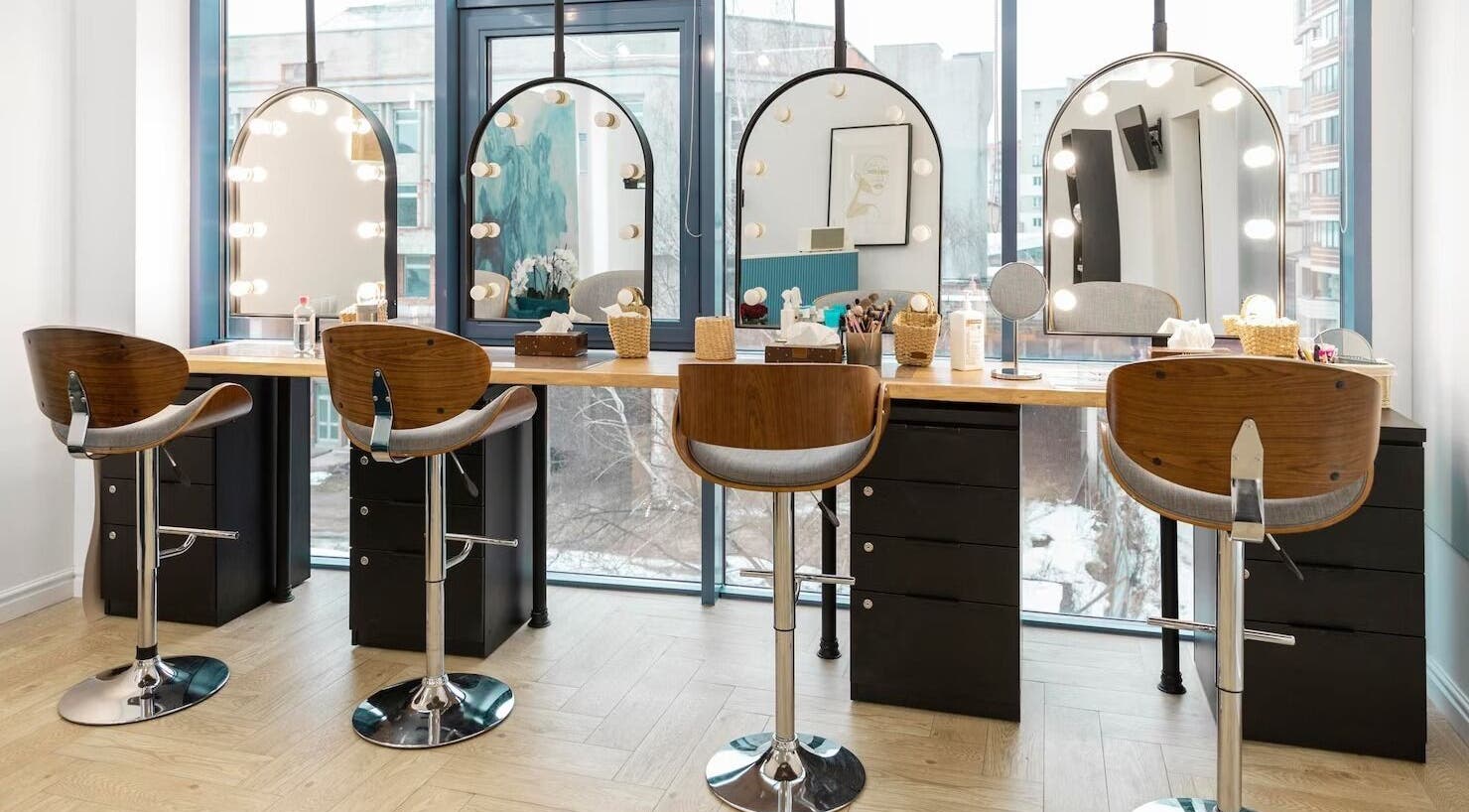 Stylish salon setup at Insyra Salon, Ahmedabad, Gujarat, IN featuring chic chairs and lighted mirrors.