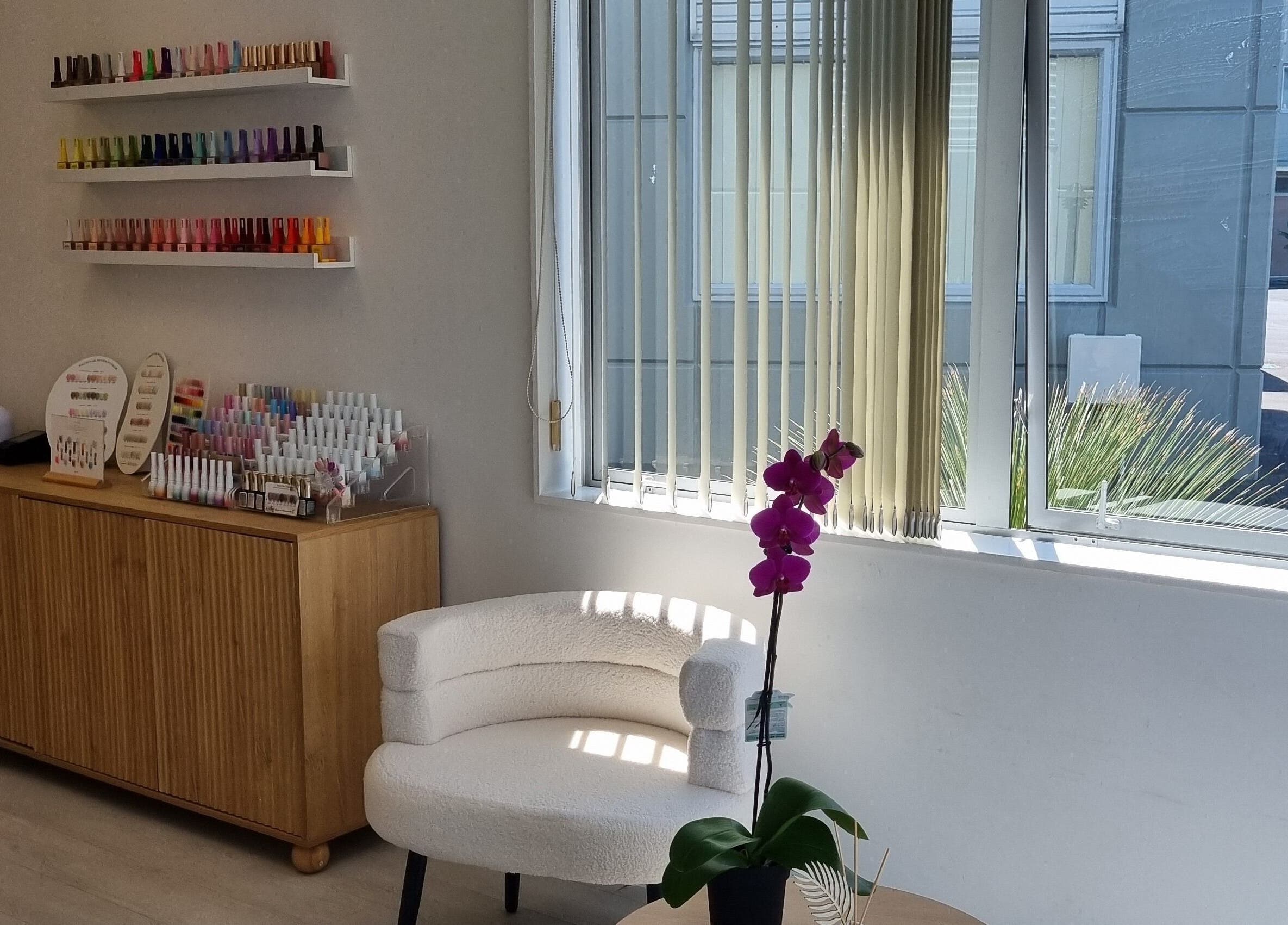 Elegant interior of Juju Beauty Studio in Auckland, NZ with nail polish display and cozy seating.