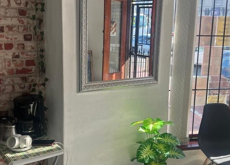 Inviting corner at Sheckies Hair and Beauty Salon, Cape Town, Western Cape, ZA with a mirror and cozy seating.