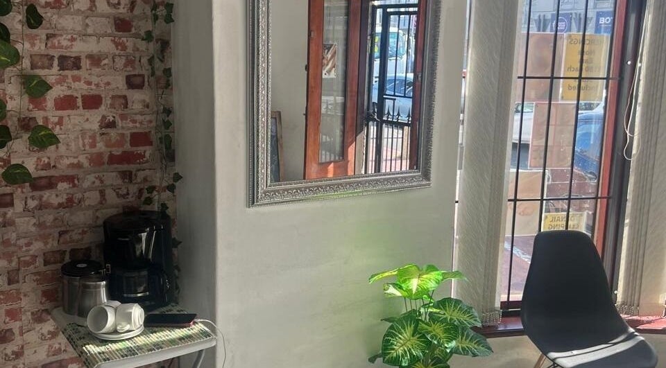 Inviting corner at Sheckies Hair and Beauty Salon, Cape Town, Western Cape, ZA with a mirror and cozy seating.