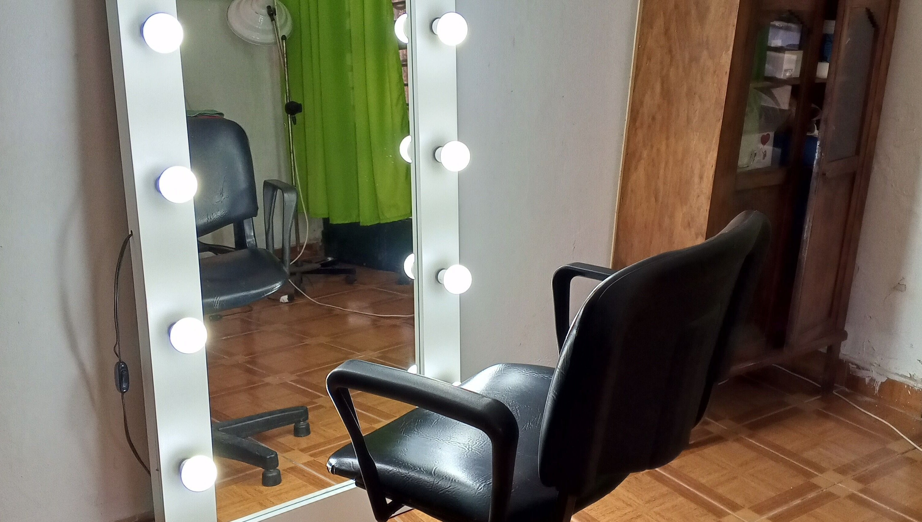 Silla de barbero frente a un espejo iluminado en Uriel Barbers, Rosario, Santa Fe, AR.