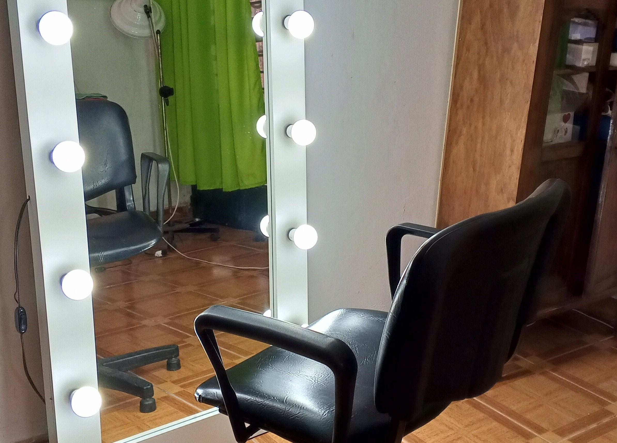 Silla de barbero frente a un espejo iluminado en Uriel Barbers, Rosario, Santa Fe, AR.