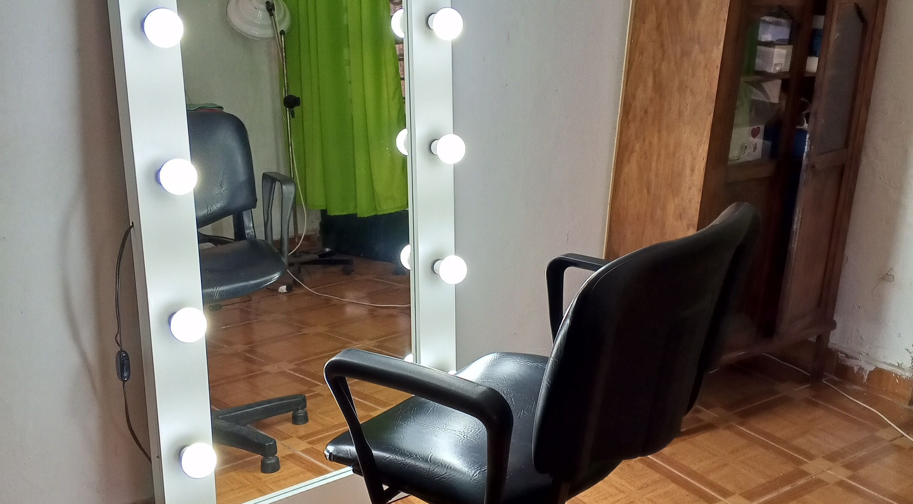Silla de barbero frente a un espejo iluminado en Uriel Barbers, Rosario, Santa Fe, AR.