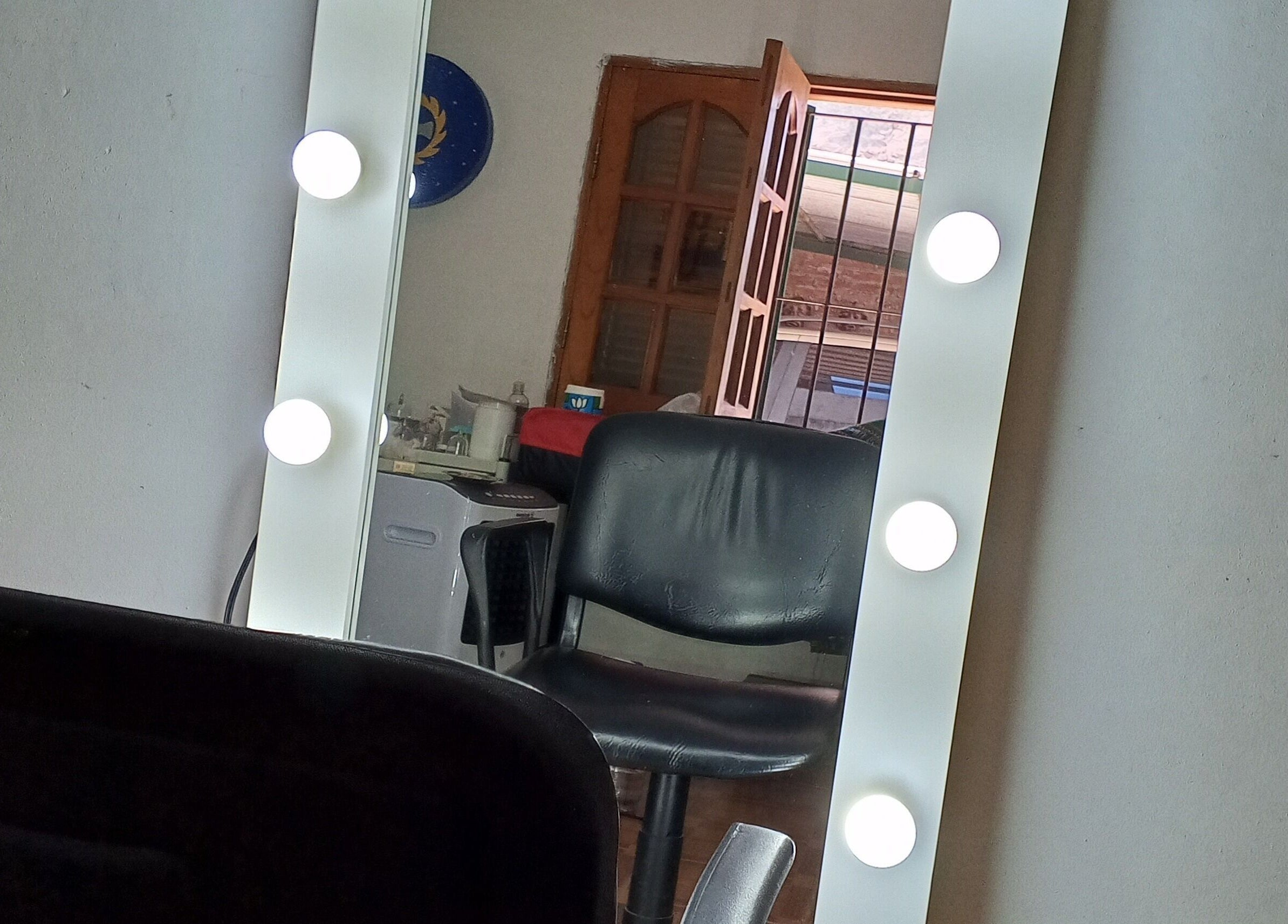 Espejo de maquillaje iluminado en Uriel Barbers, Rosario, Santa Fe, AR, combinado con silla negra.