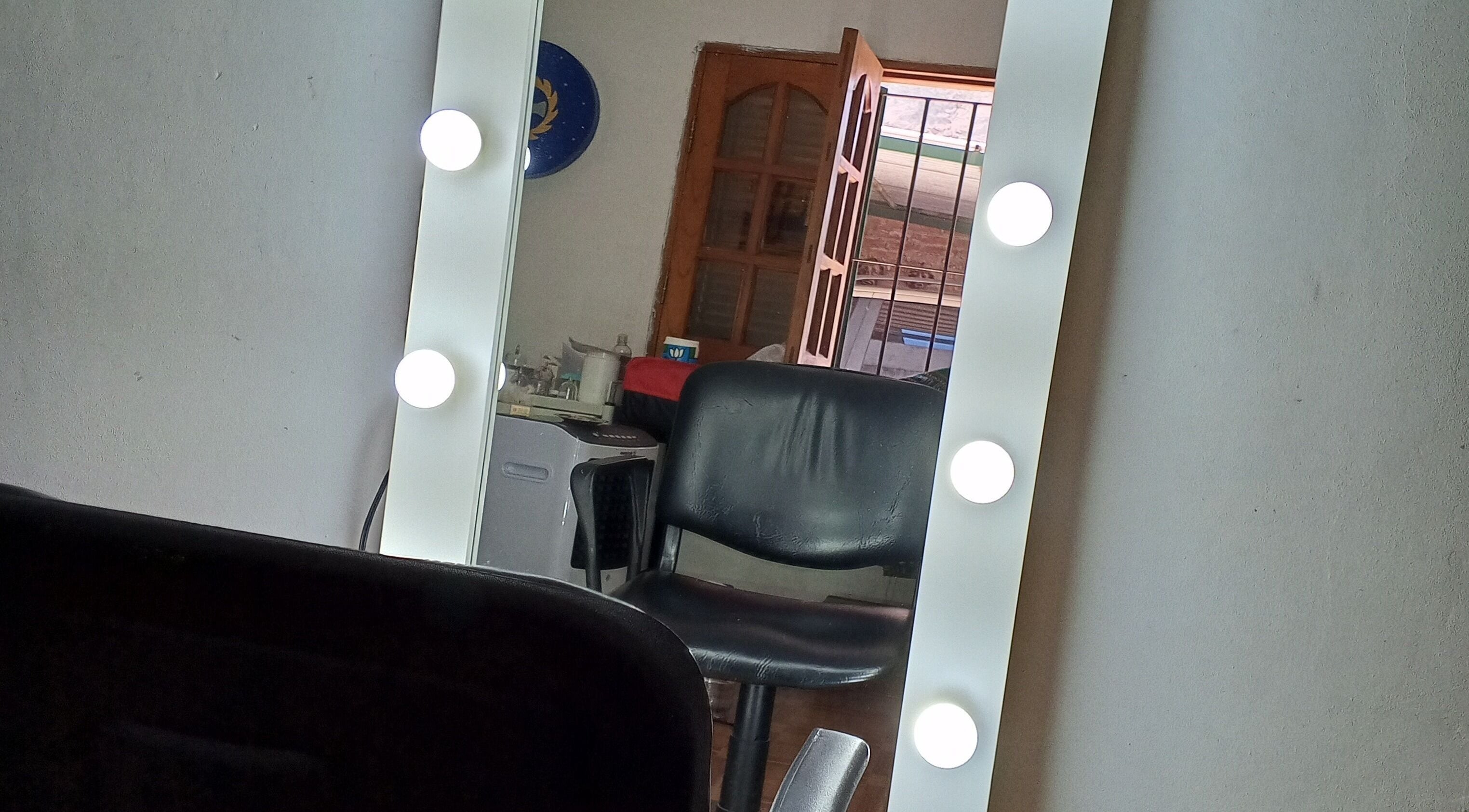 Espejo de maquillaje iluminado en Uriel Barbers, Rosario, Santa Fe, AR, combinado con silla negra.