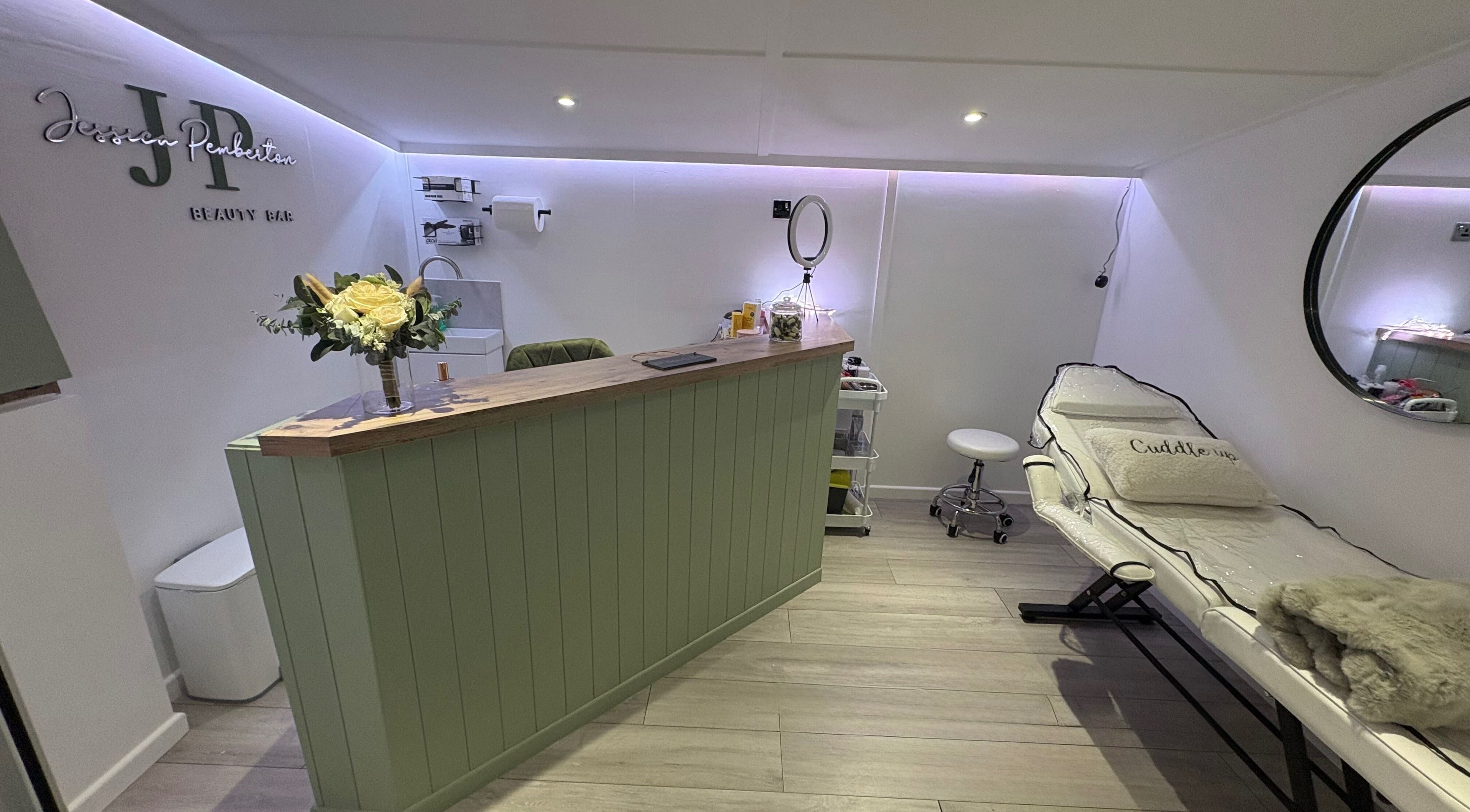 Reception and treatment room at JP Beauty Bar, Standish, England, GB, with calming decor and floral accents.