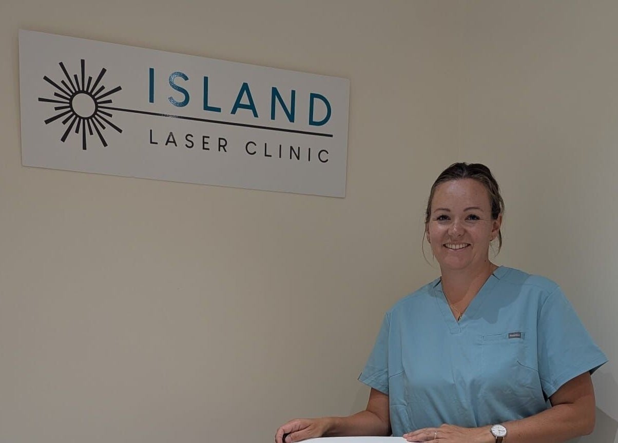A smiling staff member at Island Laser Clinic, Hayling Island, England, GB, standing proudly by the clinic sign.
