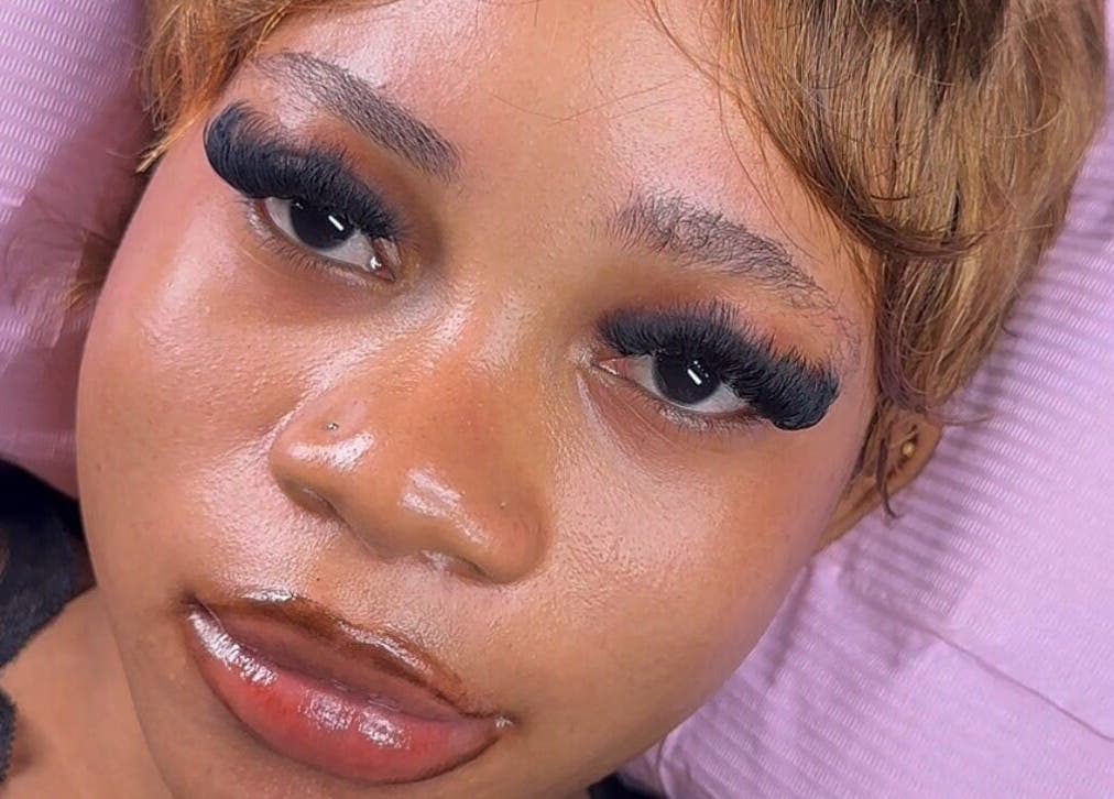 Close-up of lush eyelash extensions from Getlashedby_d.a in Lagos, Lagos, NG on a pink cushion.