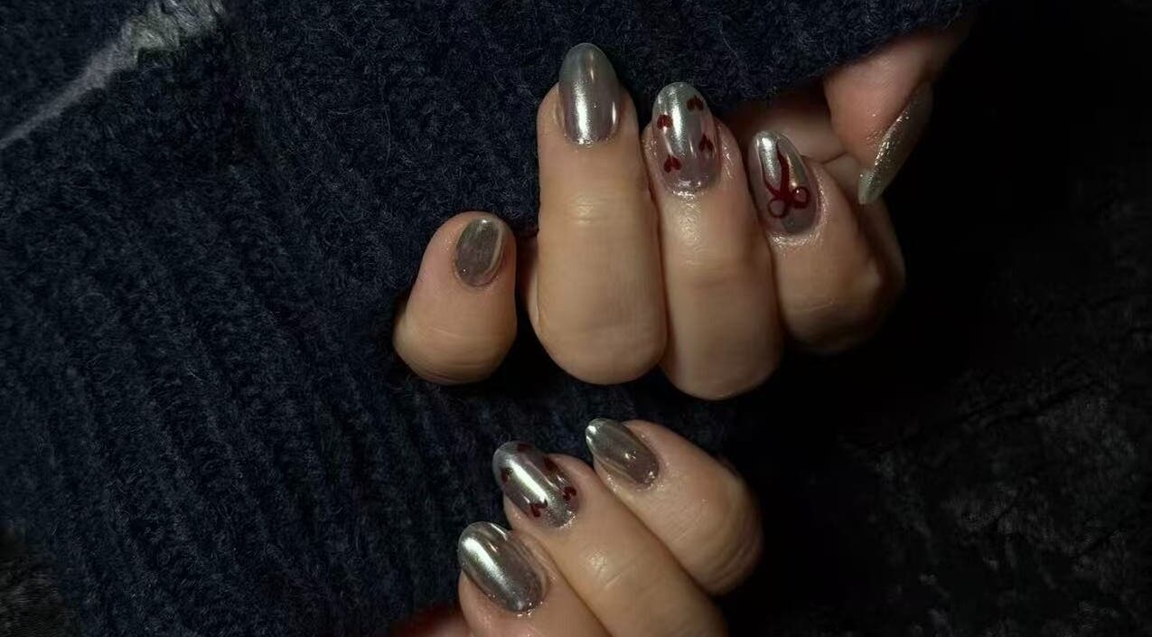 Shiny chrome nails with red heart designs at Last Quarter Nail, Melbourne, Victoria, AU.