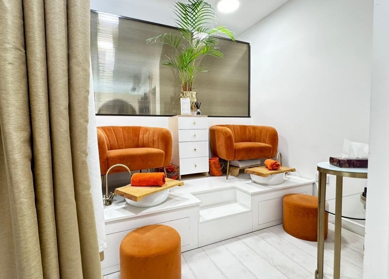 Relaxing pedicure area at MP Nails and Beauty, Northampton, England, GB with plush orange chairs and foot baths.