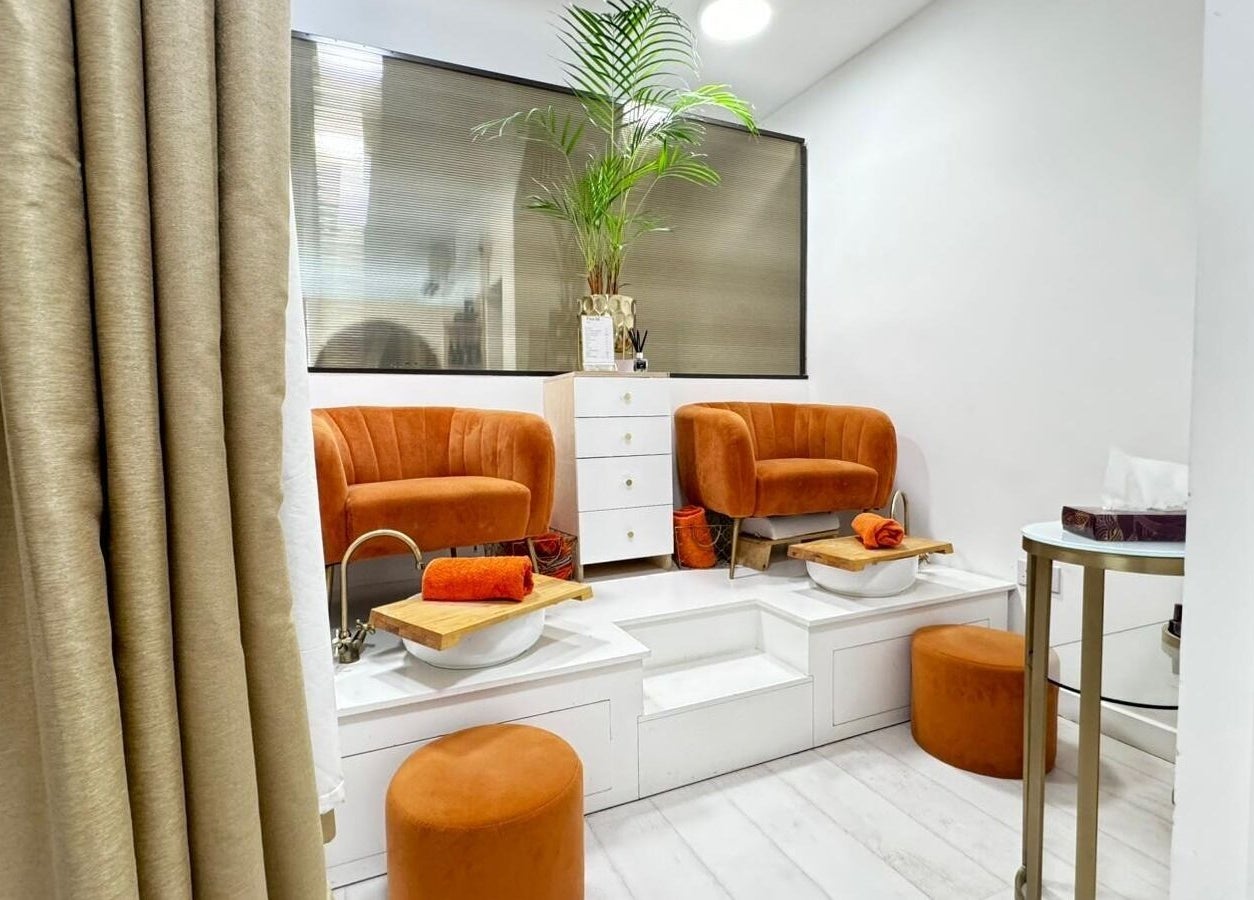 Relaxing pedicure area at MP Nails and Beauty, Northampton, England, GB with plush orange chairs and foot baths.