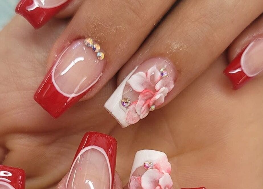 Floral-accented red nails from Nails by Yuli, Greenacres, Florida, US, offering elegant nail art design.