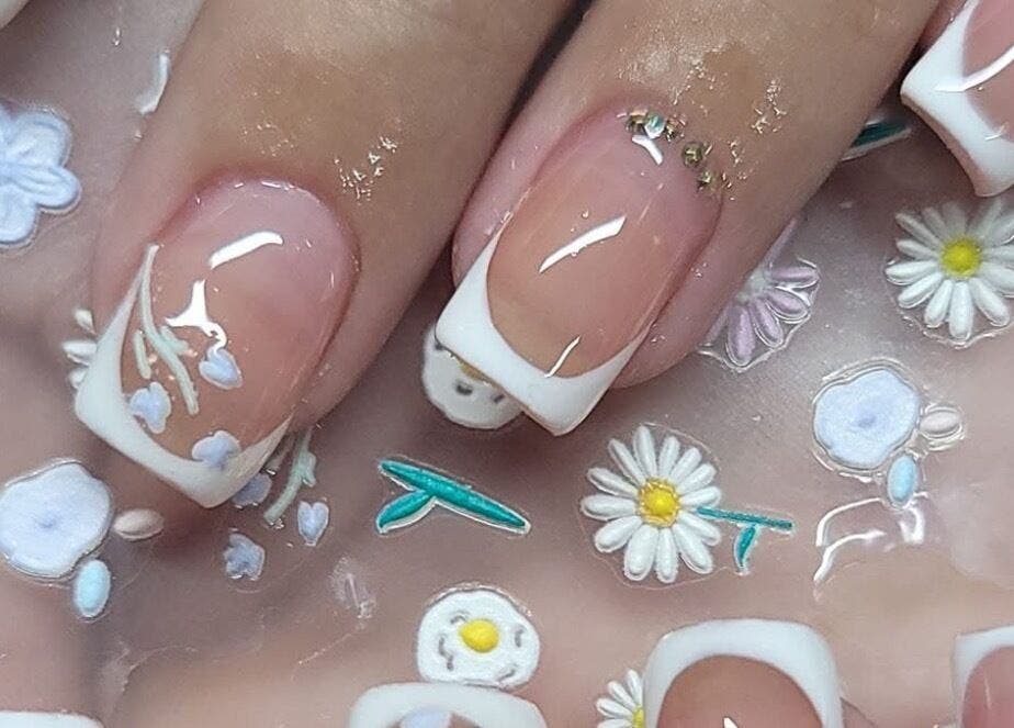 Elegant floral nail art design at Nails by Yuli, Greenacres, Florida, US, showcasing intricate white patterns.